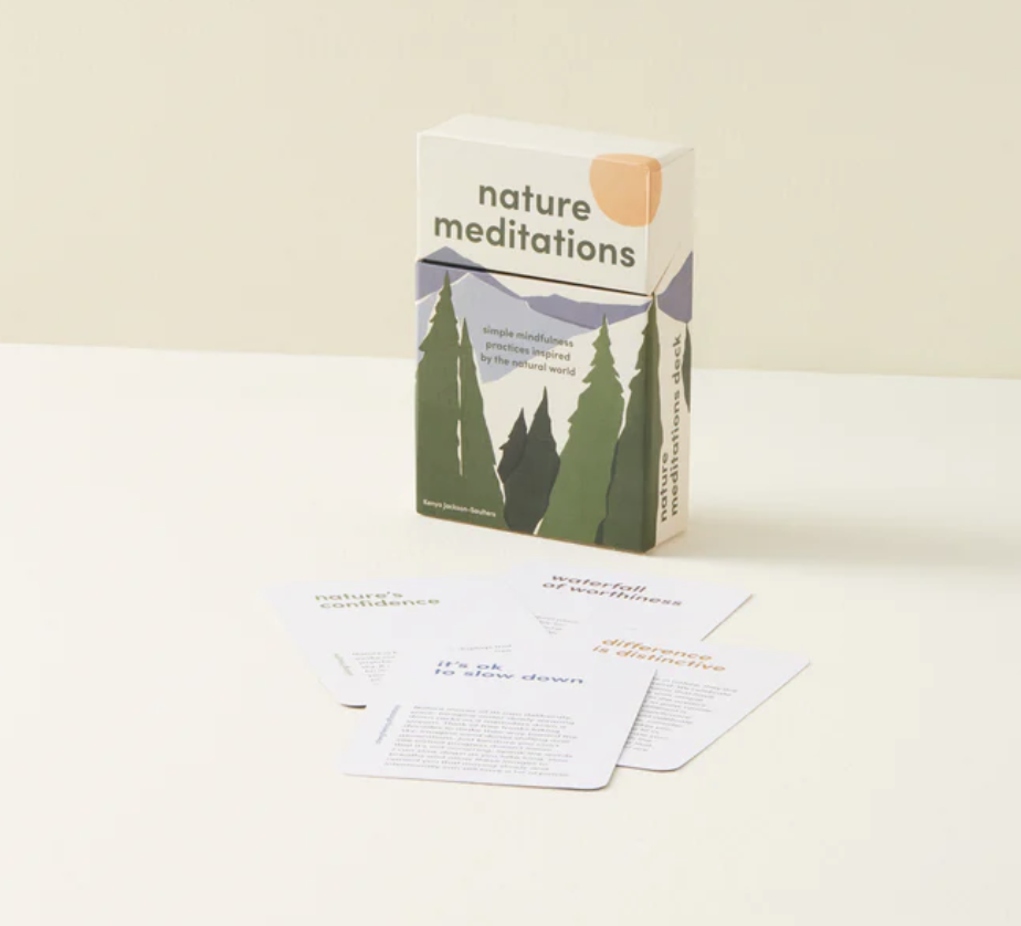 A box titled 'nature meditations' with illustrations of mountains and trees, along with several sheets of paper with meditation prompts or instructions.