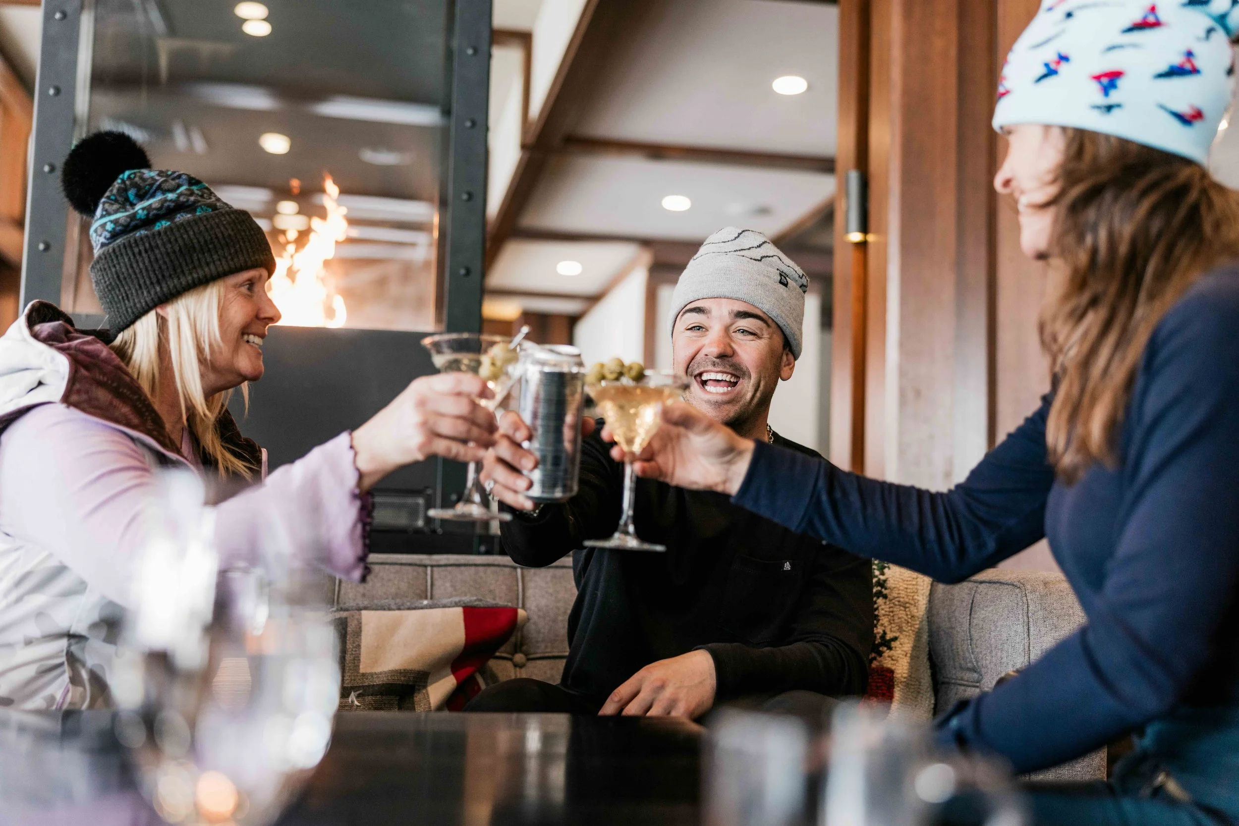 a group of friends at a cocktail bar wearing fourbital beanies
