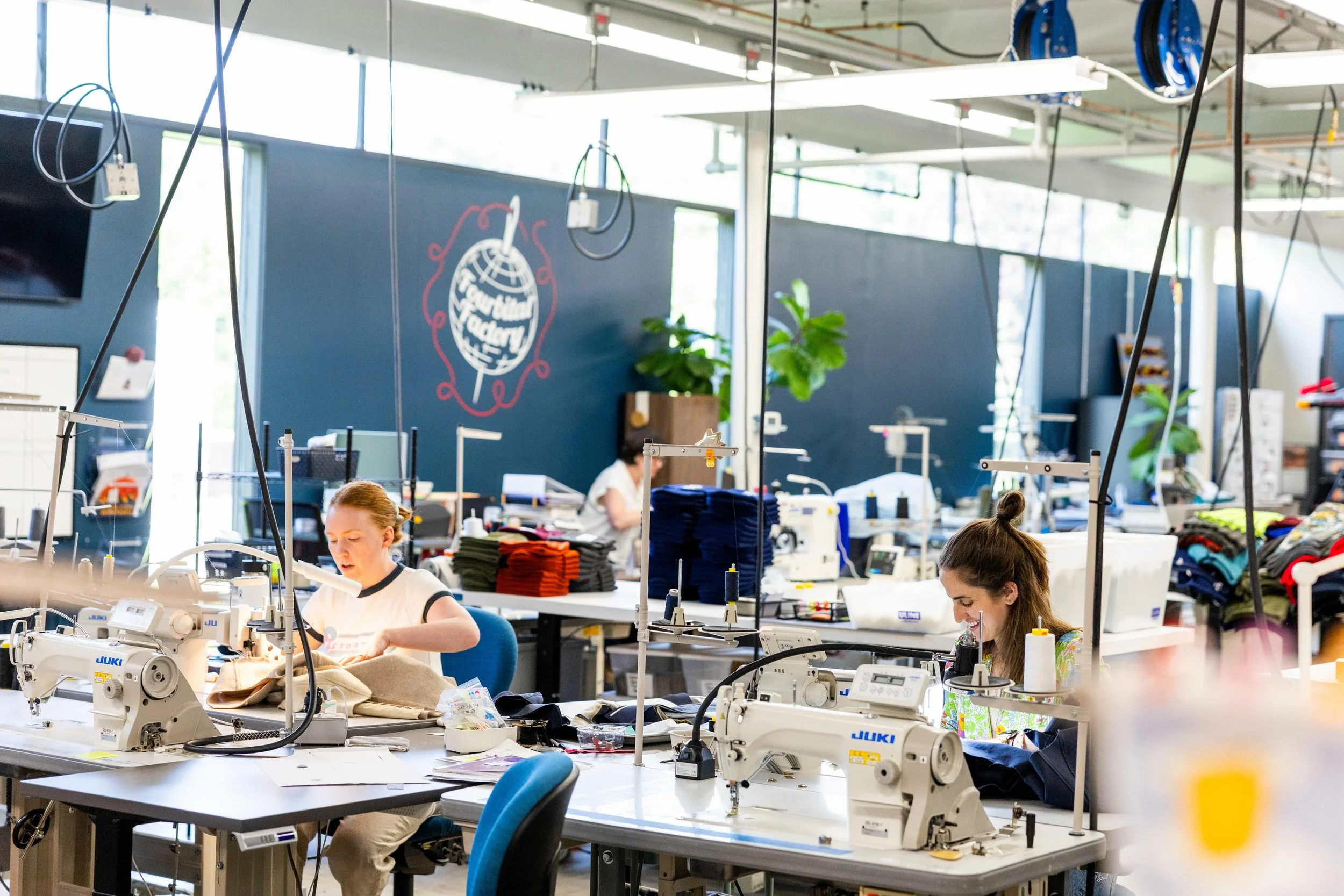 photo of two women knitting beanies at fourbital factory in burlington vermont
