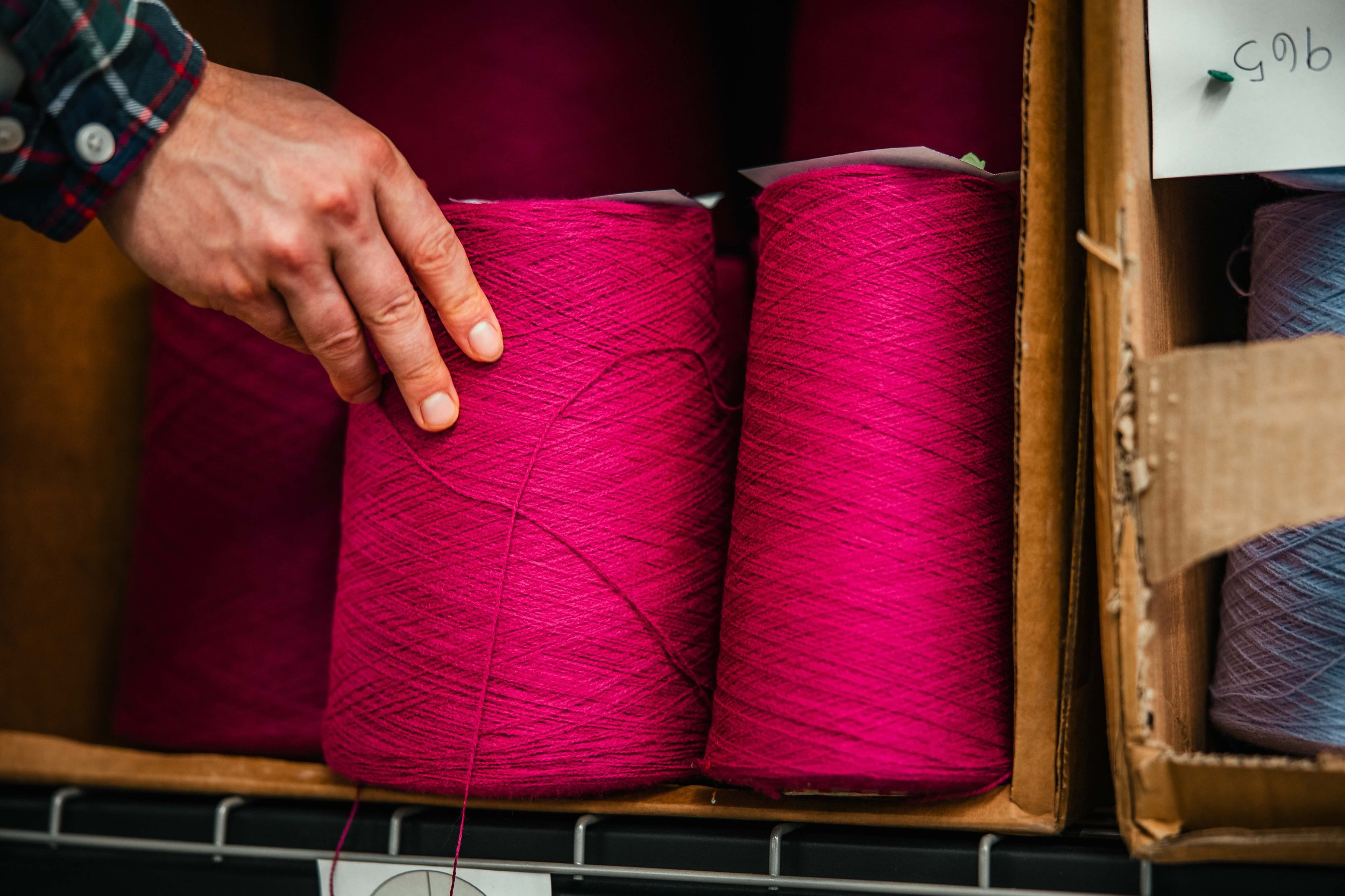 a roll of magenta premium yarn used to make beanies at fourbital factory in burlington vermont