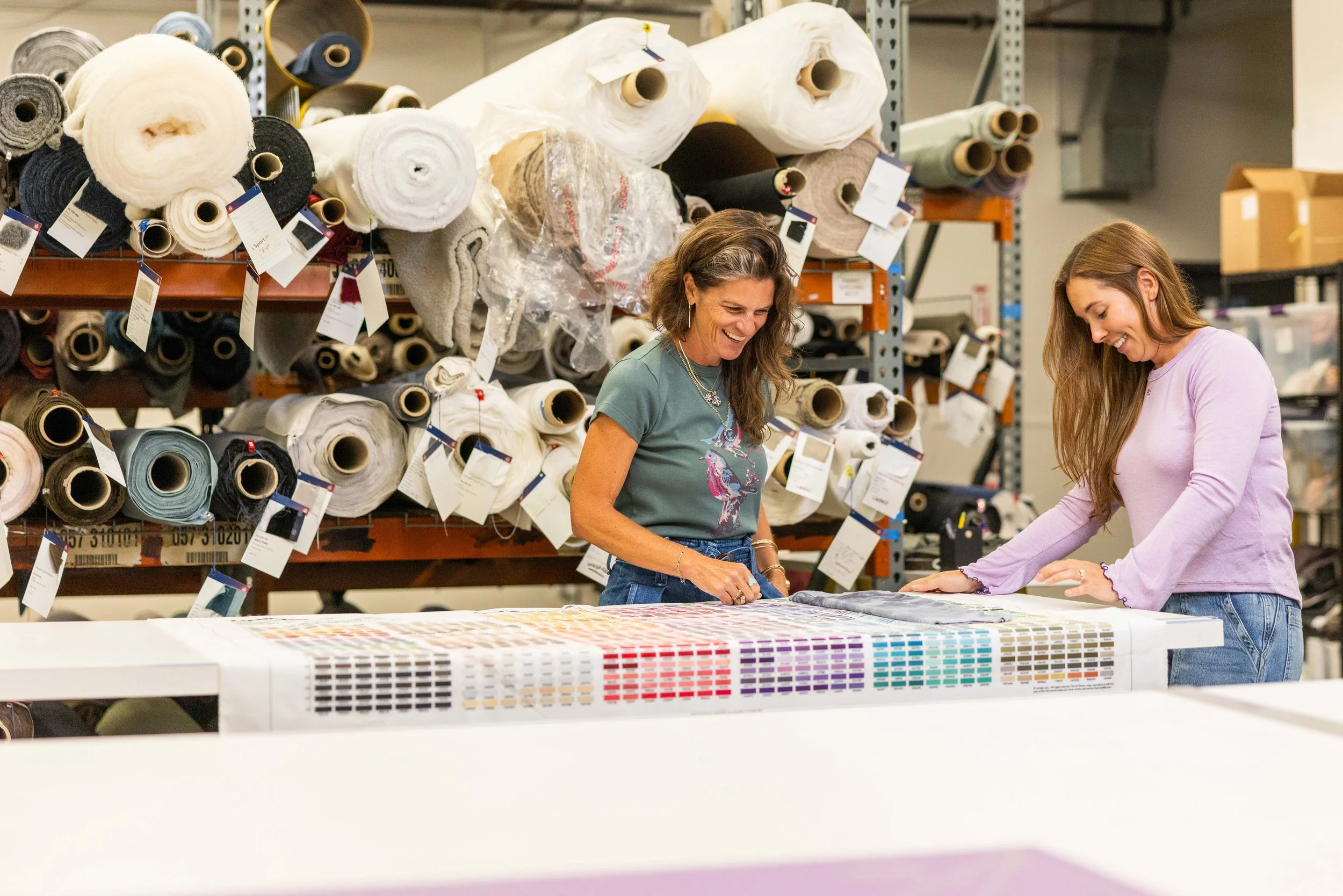 two woman inside fourbital factory reviewing color samples for beanies