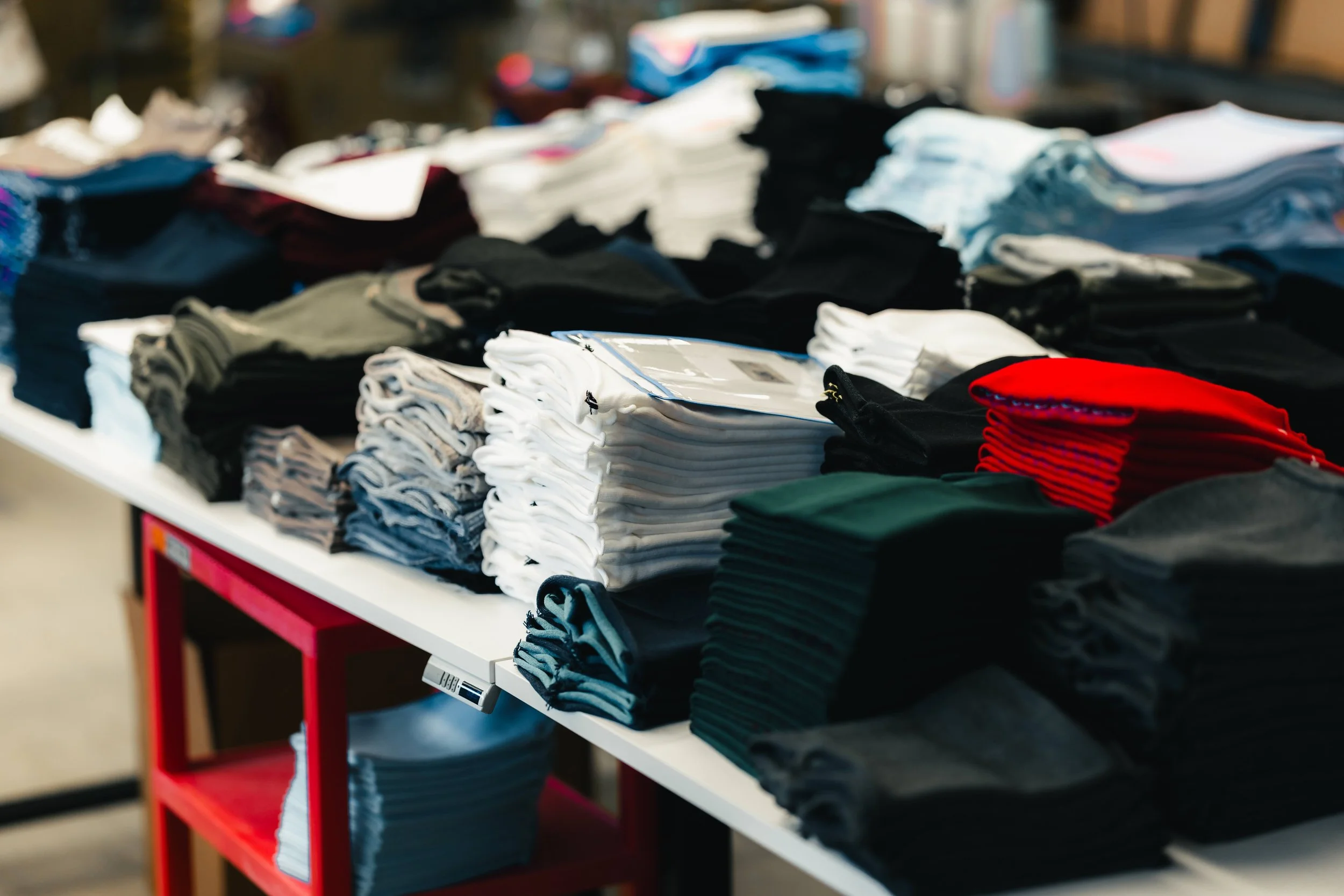 fourbital factory beanies stacked up on a table ready for cutting and sewing