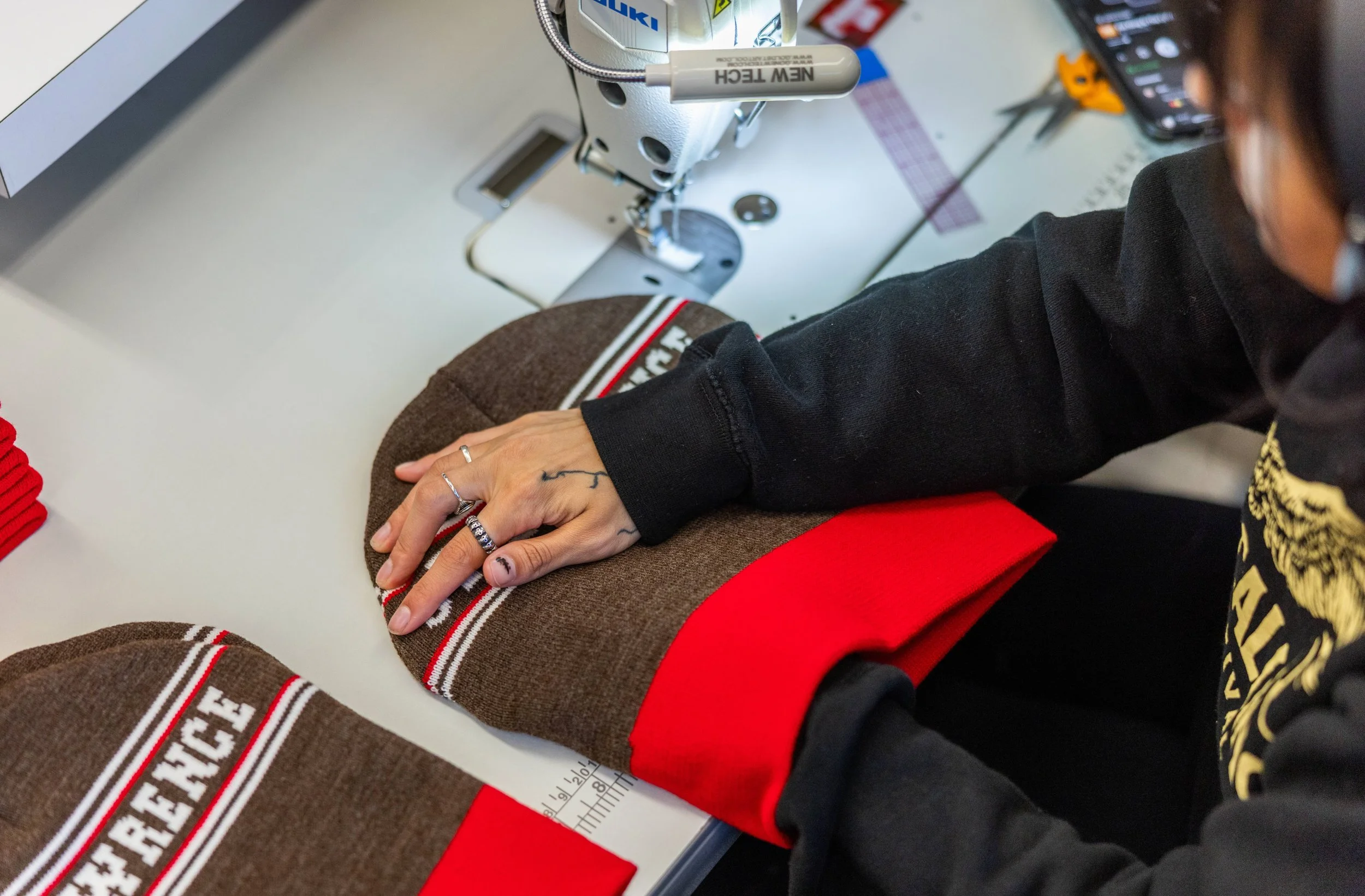 photo of a seamstress in burlington vermont at fourbital factory sewing a beanie