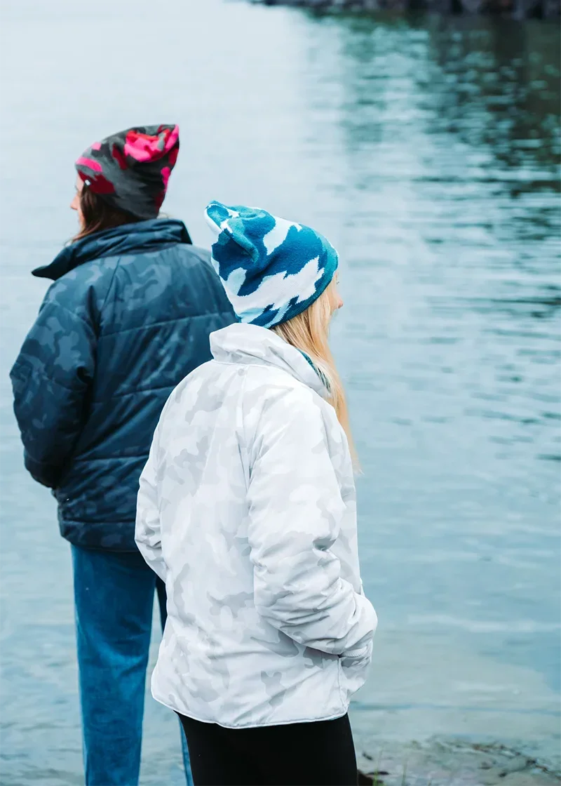 two women wearing beanies by the water in vermont