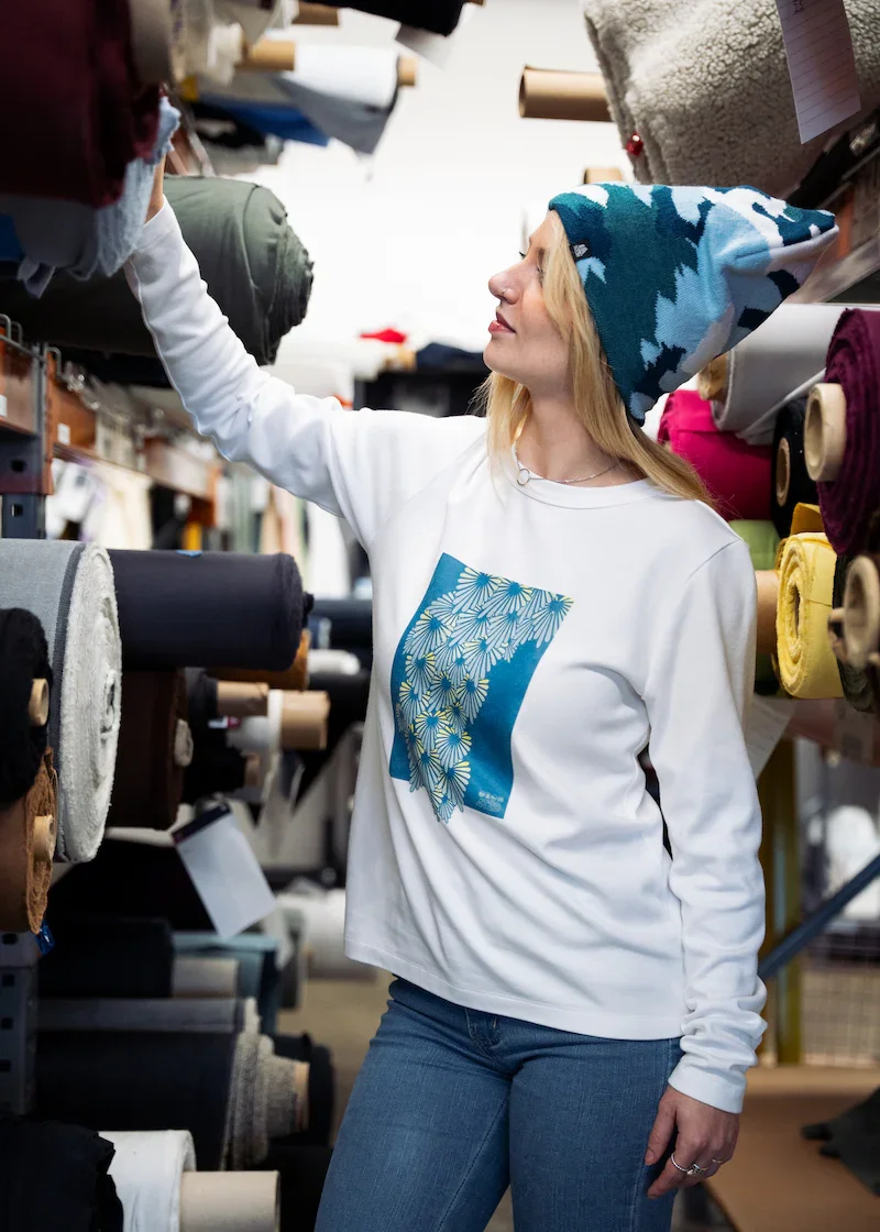 woman choosing fabric at fourbital factory wearing a jacquard print midi beanie