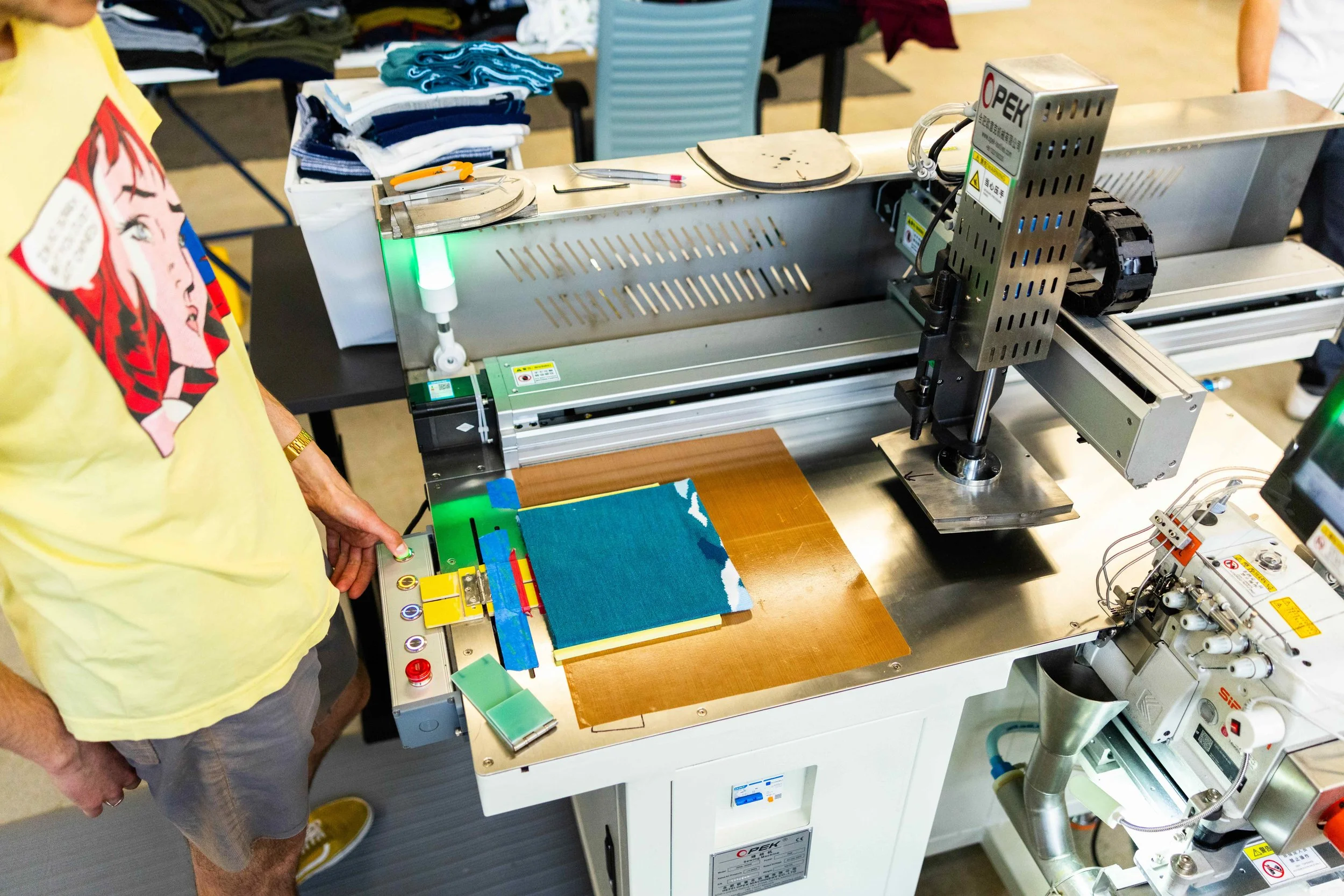 fourbital factory employee cutting fabric for a custom beanie