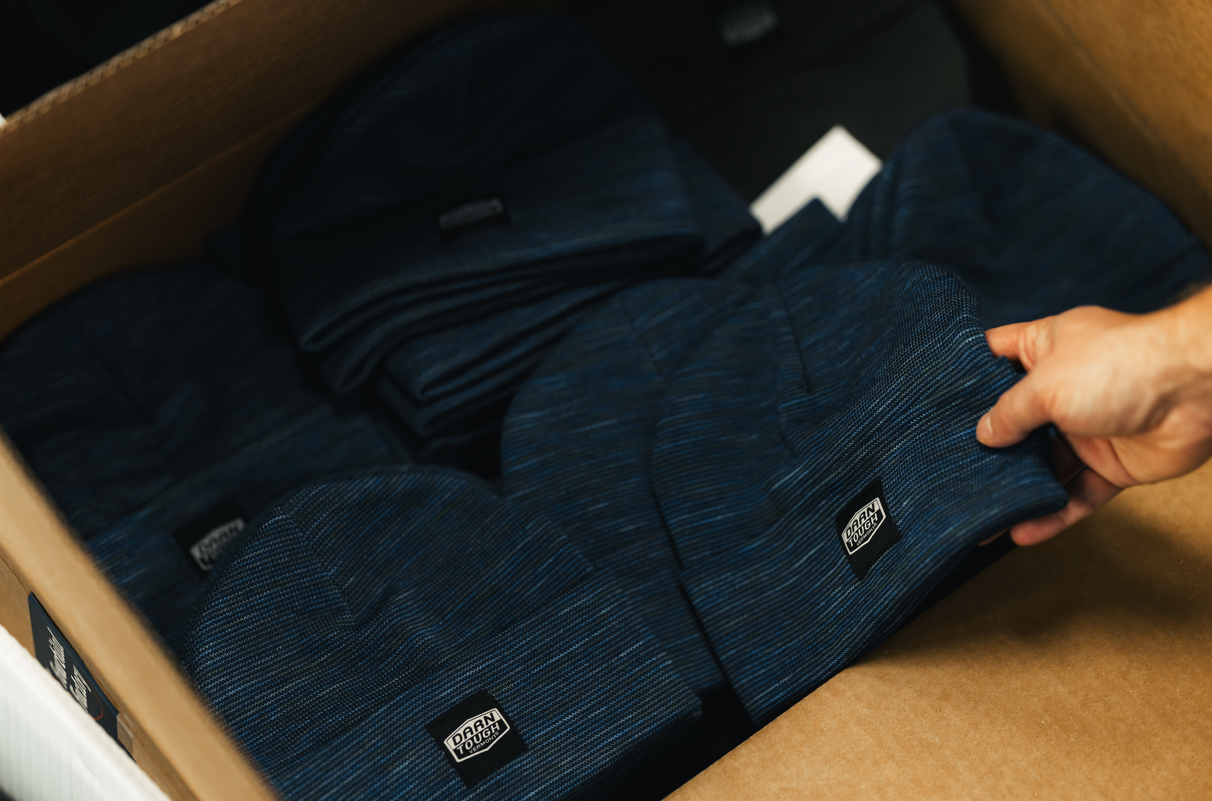a box of darn tough beanies made by fourbital factory in vermont