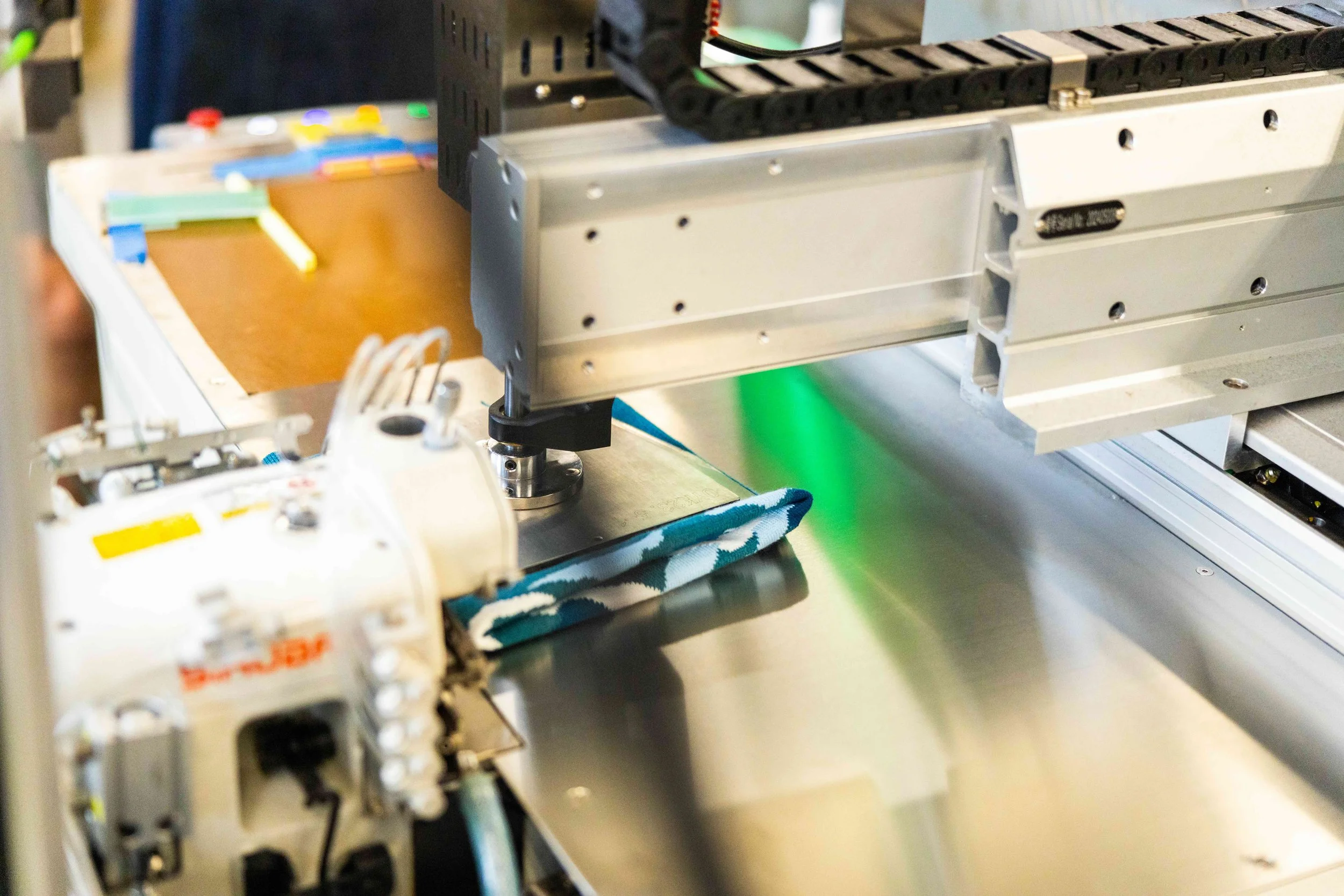 sewing machine at fourbital factory putting final touches on a custom beanie