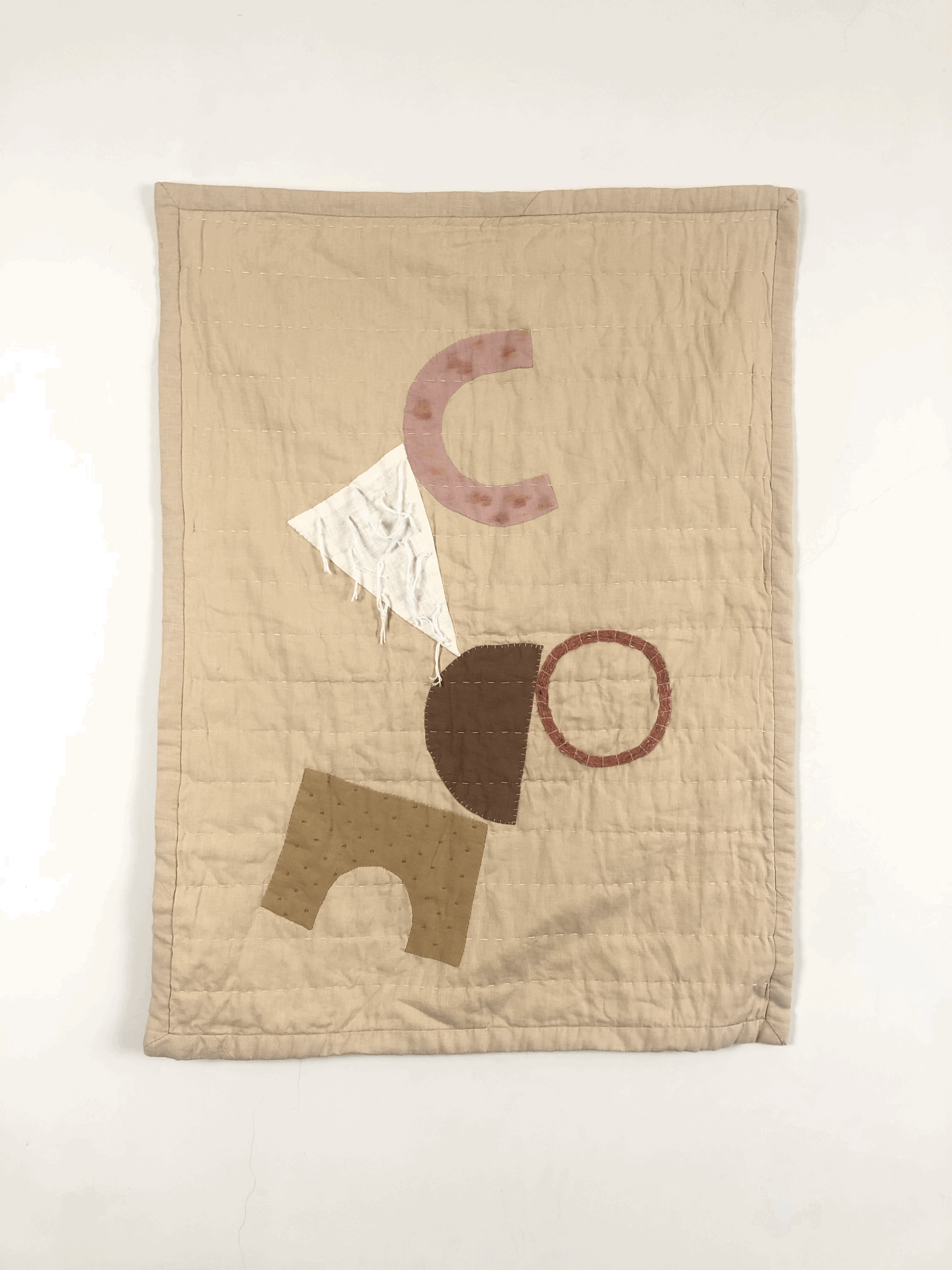 Hand quilted small baby quilt with appliqué shapes.