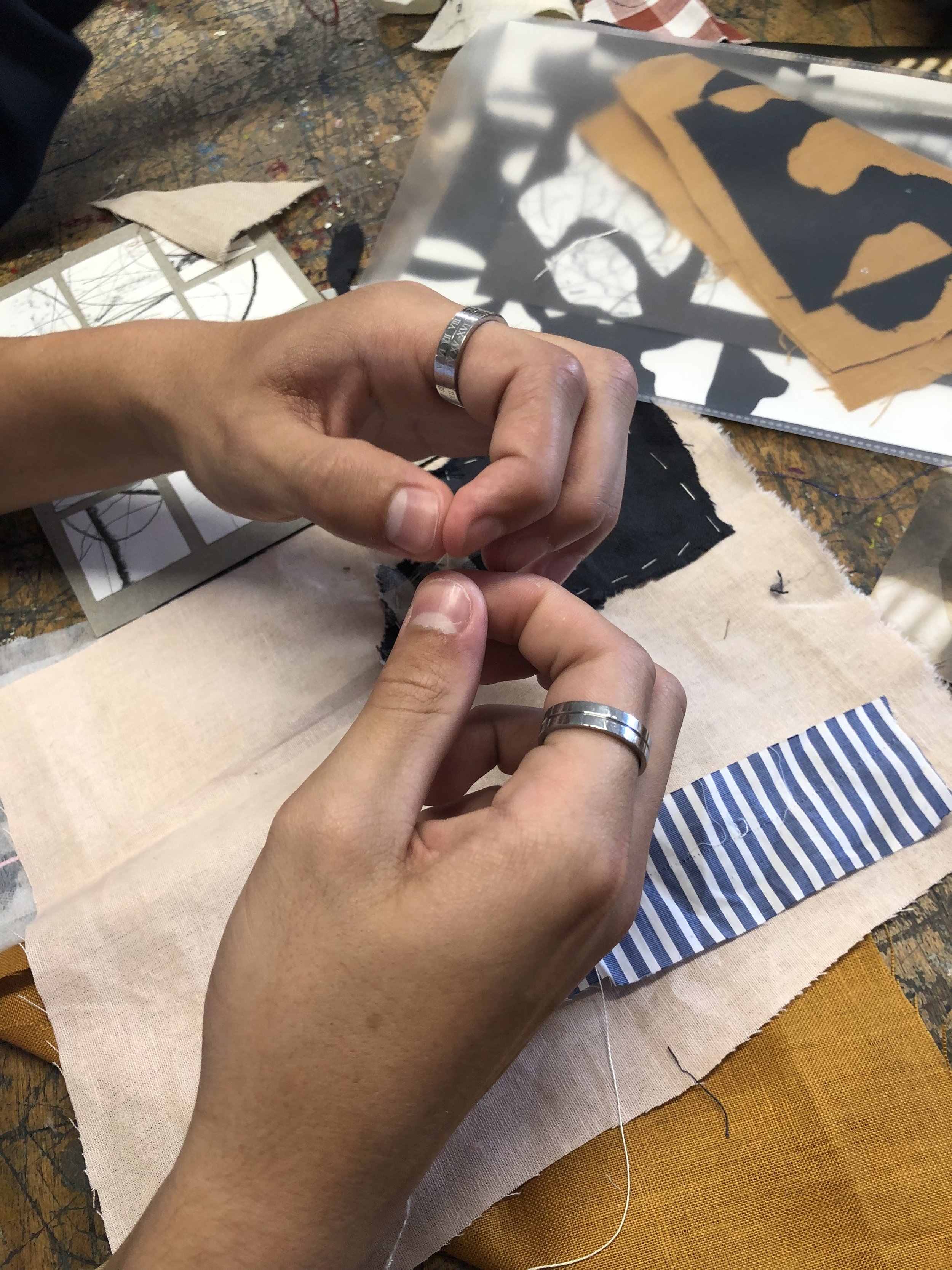 Hands creating a textile collage