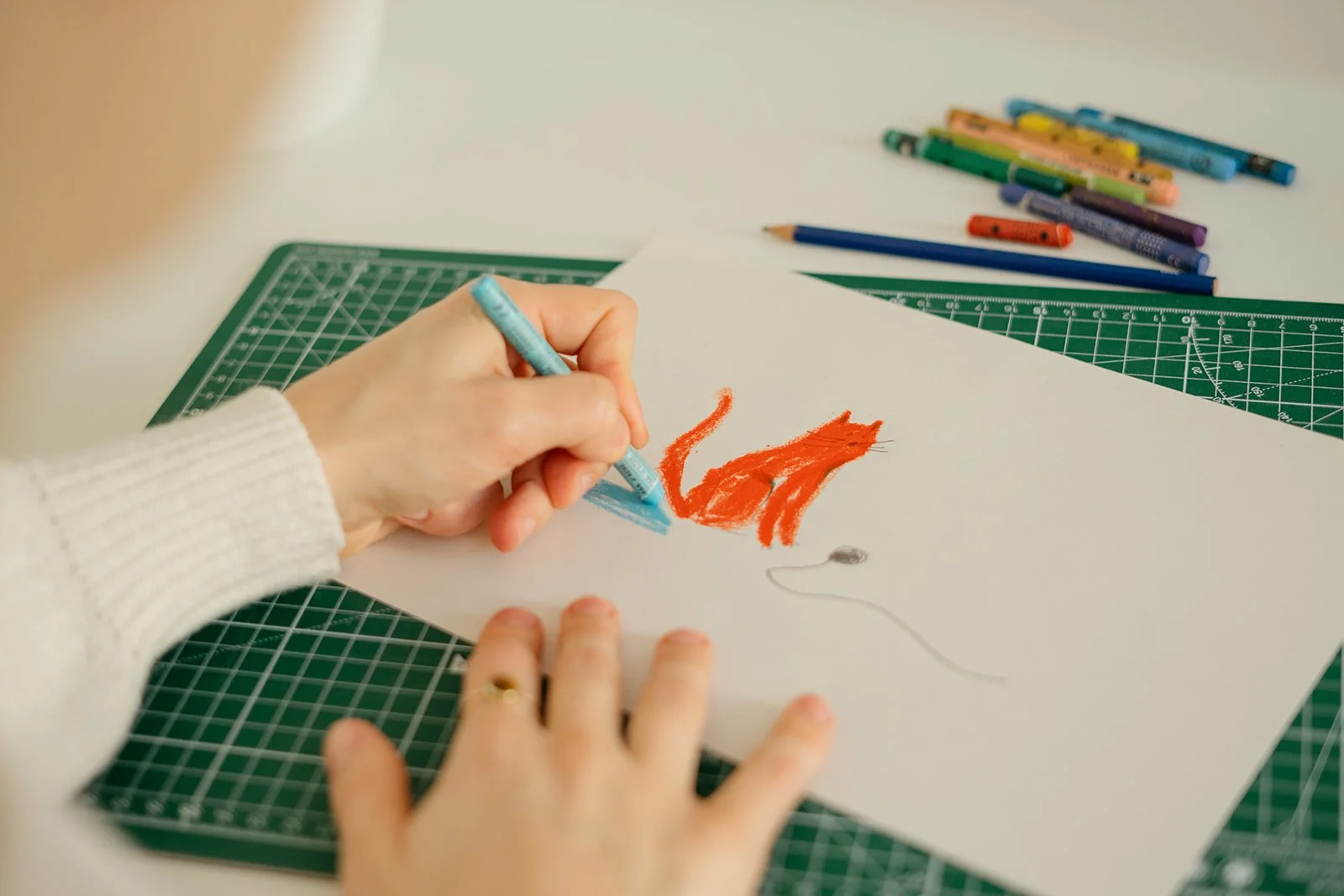 mani che disegnano con pastello a cera