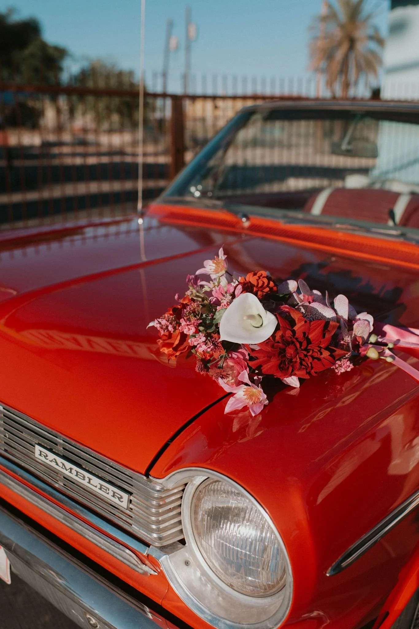 Luxury silk bridal bouquet in red and pink tones displayed on a vintage red car during a Las Vegas destination wedding elopement