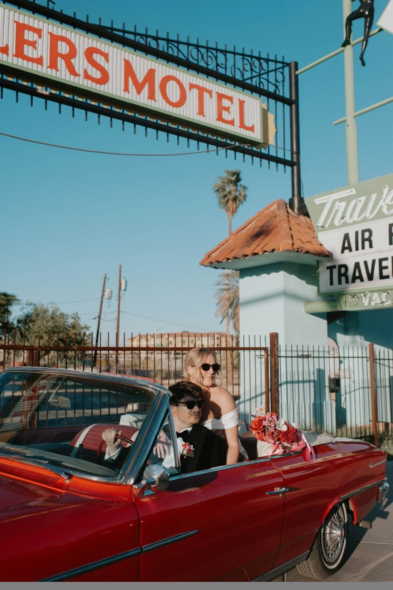 Couple sitting in a vintage car during a Las Vegas elopement with silk wedding flowers and bridal bouquet