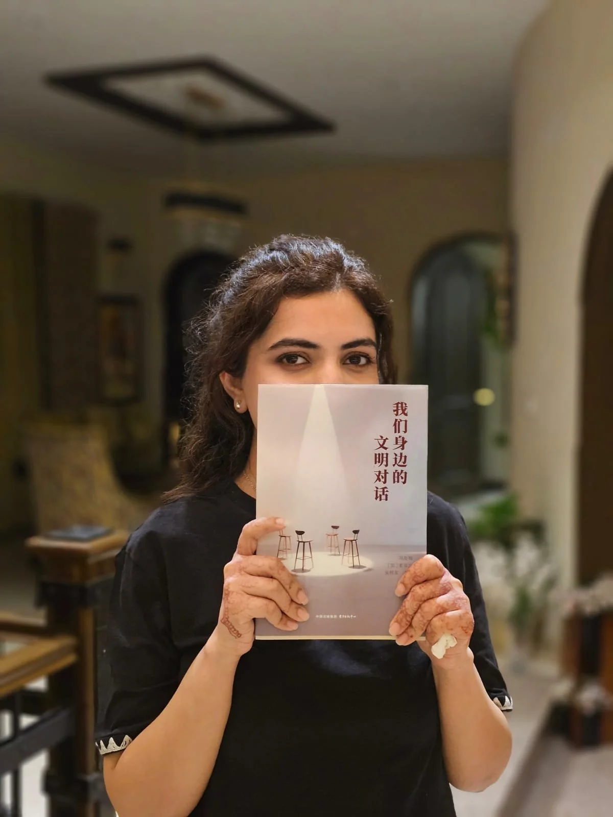 Zarfishar Tayyab holding a book she is featured in for her approach to business which involves a rooted globalism approach.