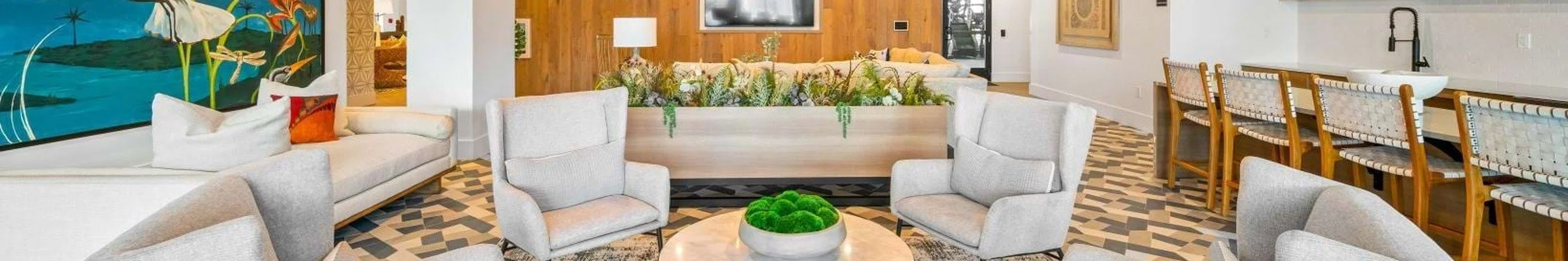 Multifamily clubroom lounge with greenery and communal seating"