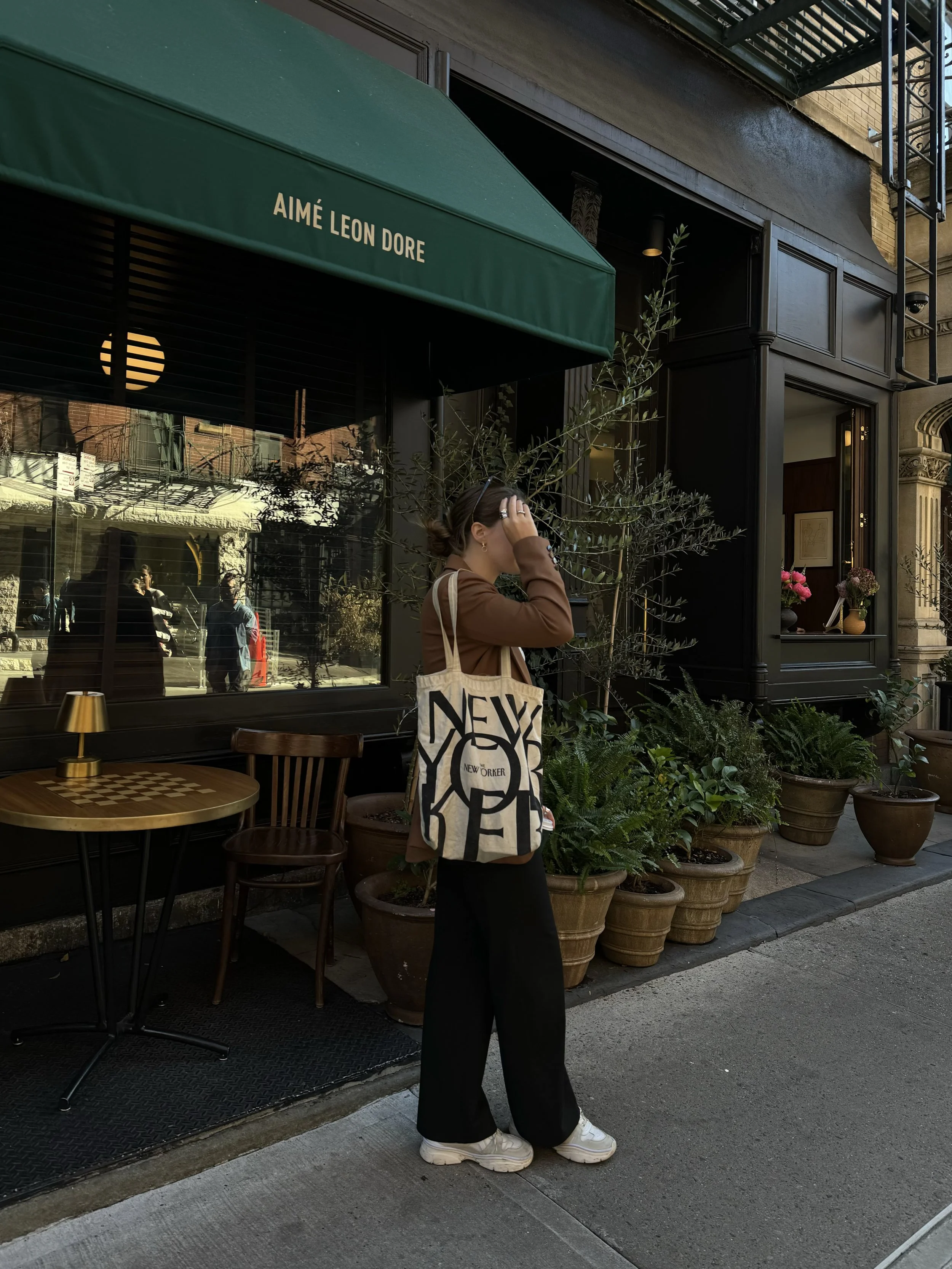 Young professional woman in Manhattan with New Yorker tote bag, reflecting NYC culture, anxiety, burnout, and therapy support.