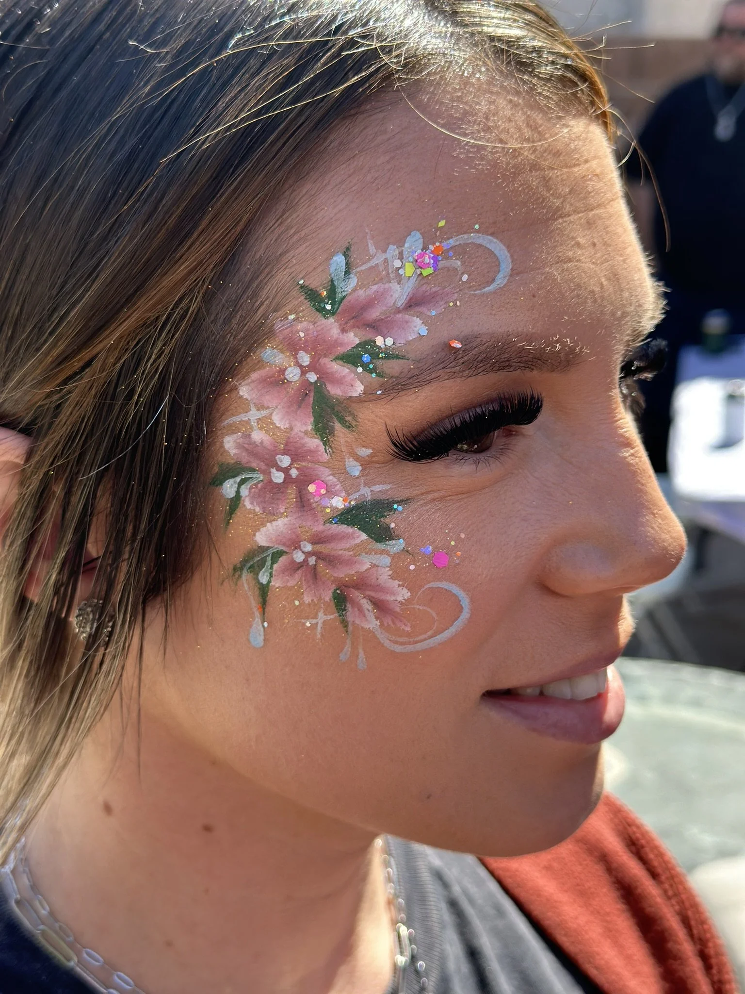 Woman with floral face painting and sparkles