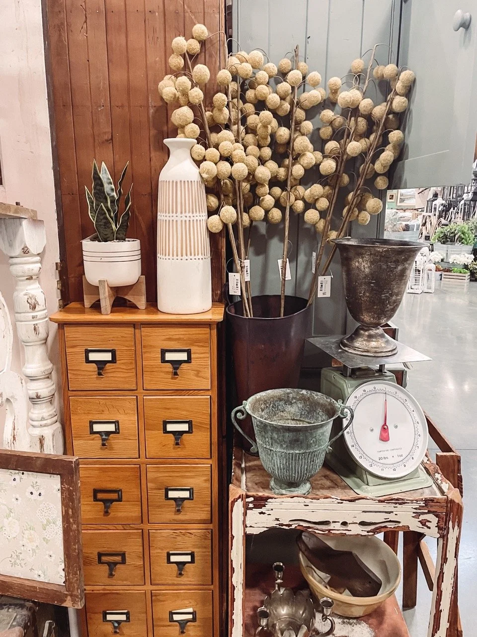 A vintage scale holding a vintage vase. 