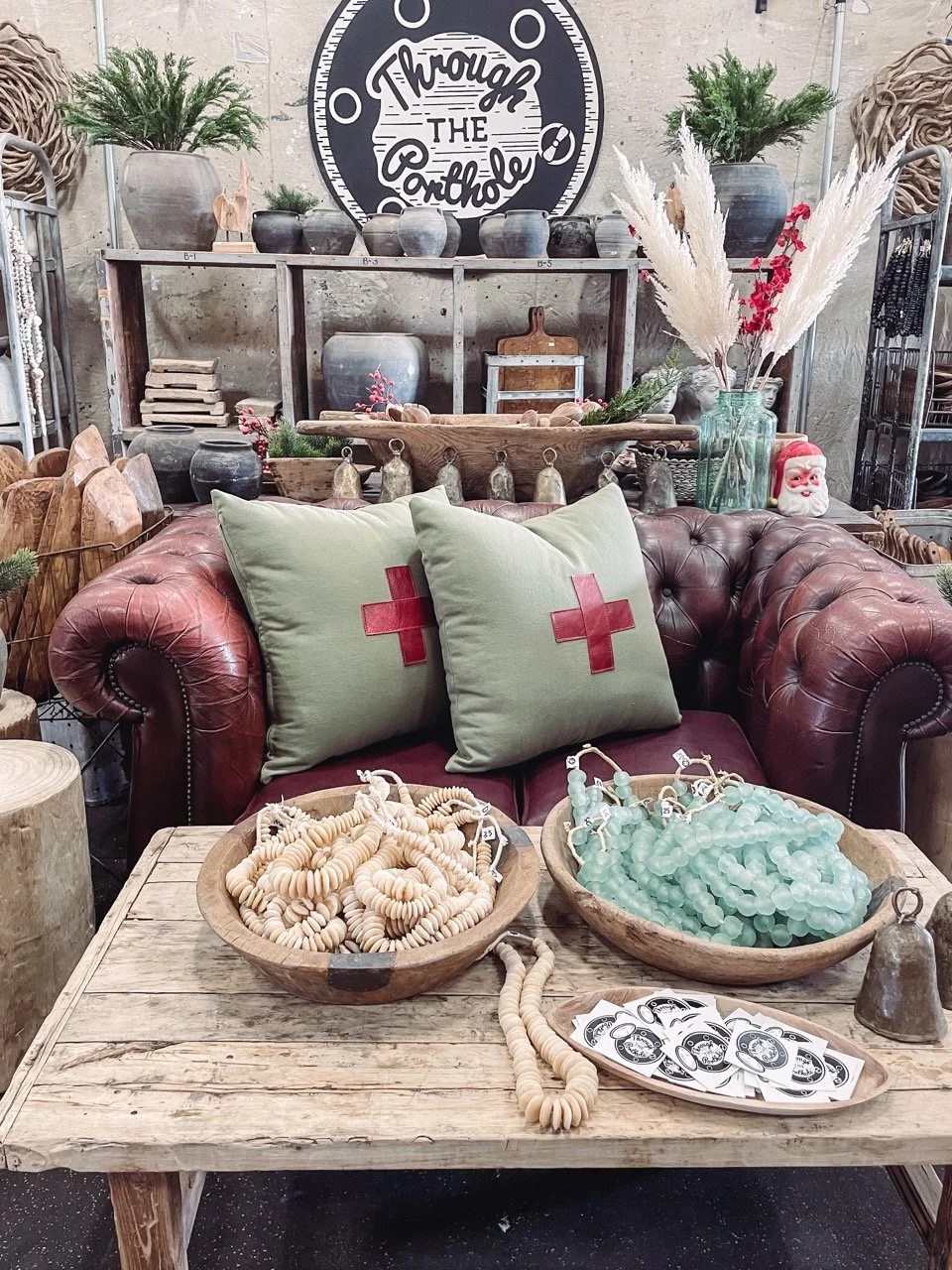 A vintage leather couch behind a rustic coffee table. 