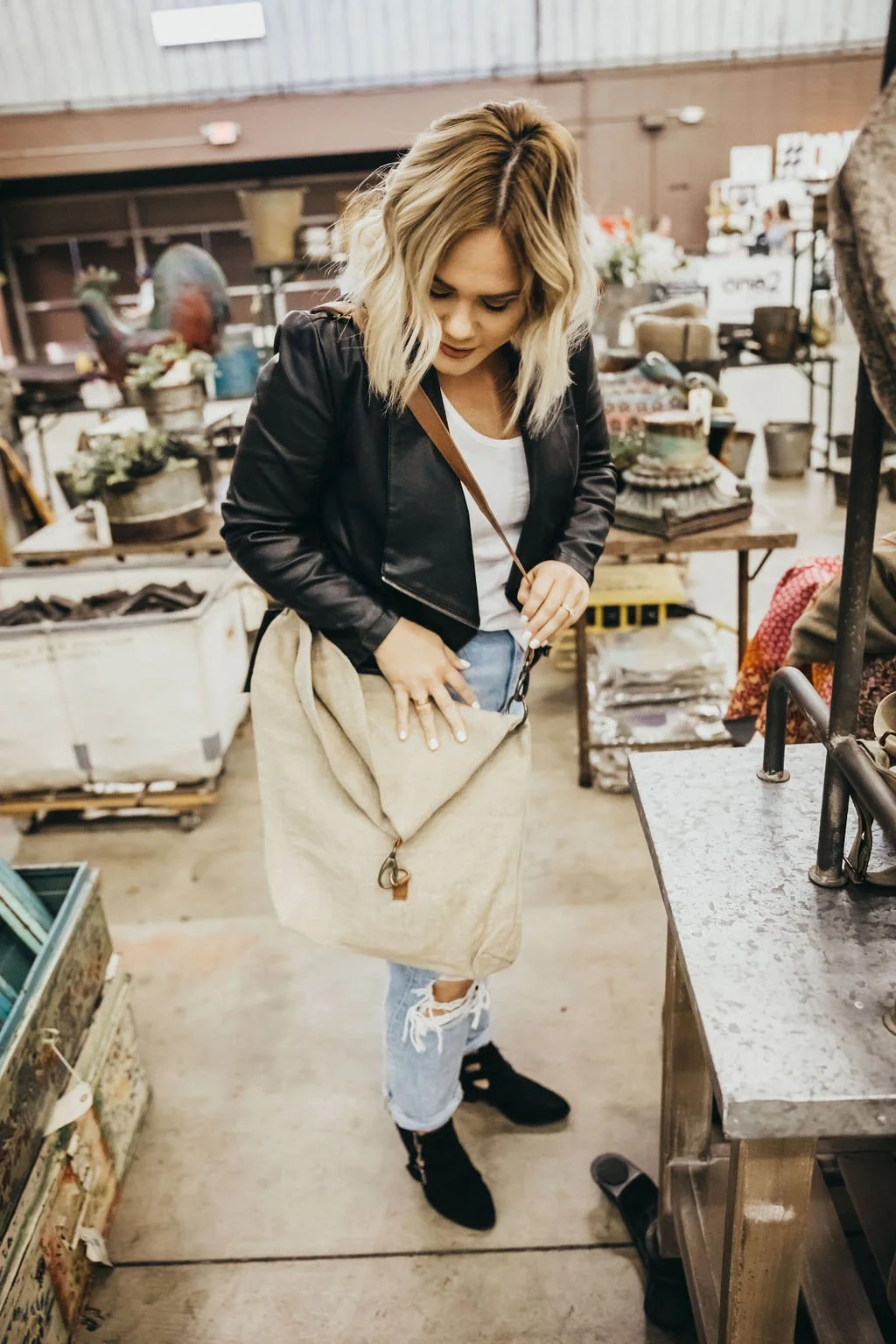 A person admiring a vintage bag at a vintage market