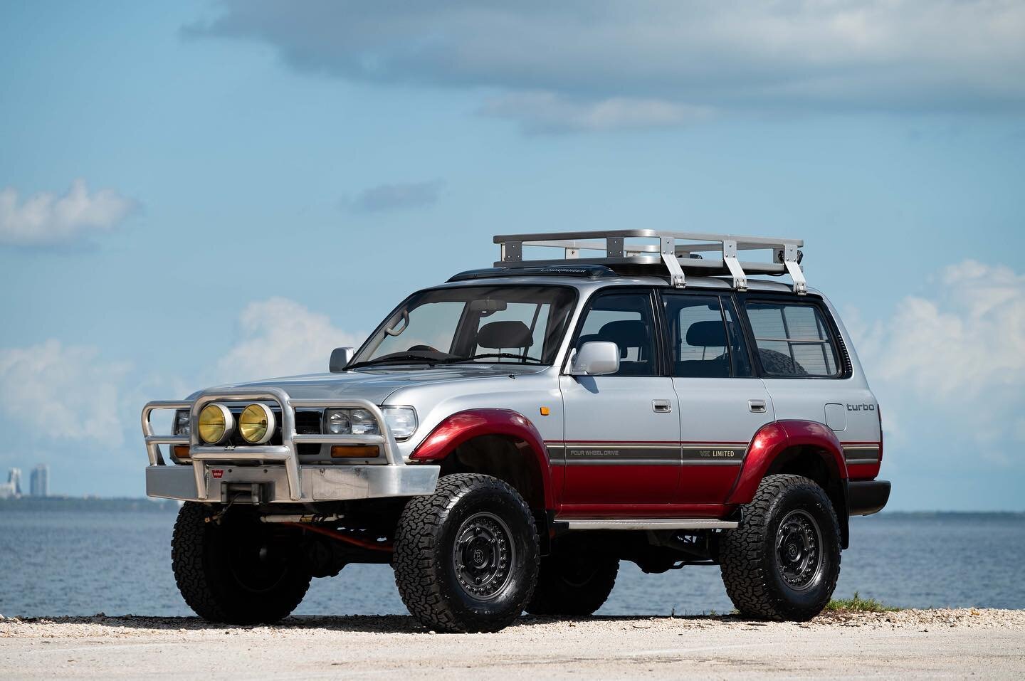 This triple locked 1992 Toyota Land Cruiser HDJ81 is a Japanese-market example that was imported into the US in May of 2021. The truck is finished in two-tone silver and red over a dark gray and silver cloth interior and is powered by the legendary T