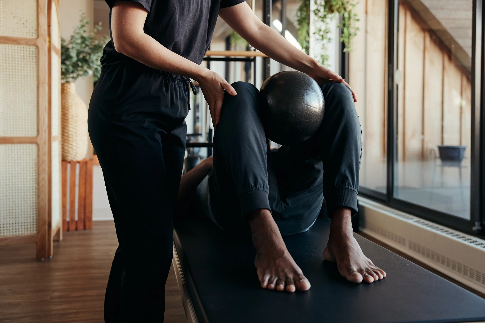 Physiotherapist guiding a client through a stability exercise during hypermobility physiotherapy