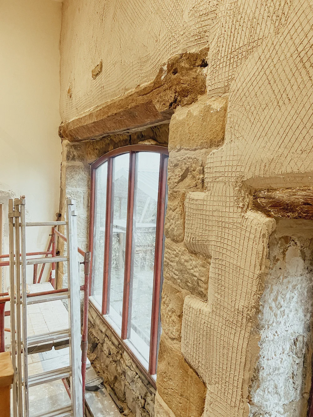 The barn window exposed, oak beam stripped, and stone threshold revealed