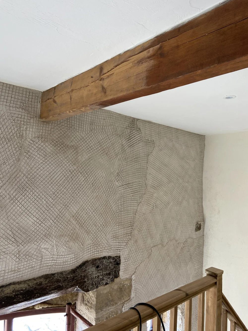 Scratch coat applied, and beginning to strip the beams