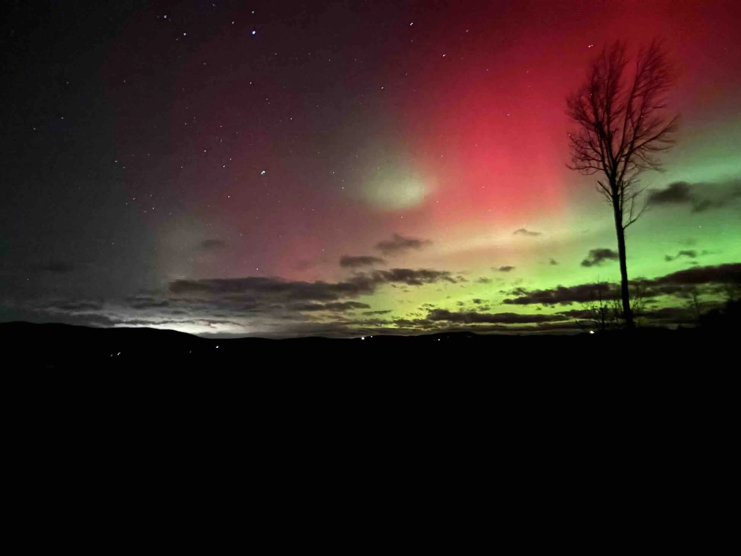 A winter night sky with aurora borealis in red and orange