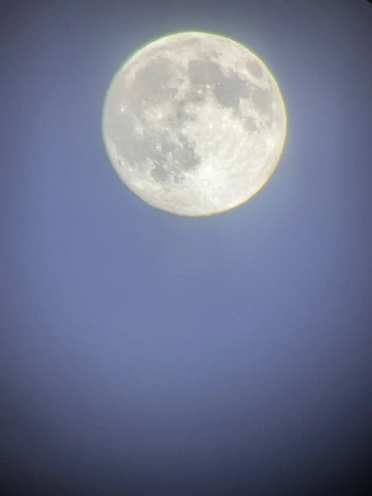 A photo of the full moon in a clear blue sky