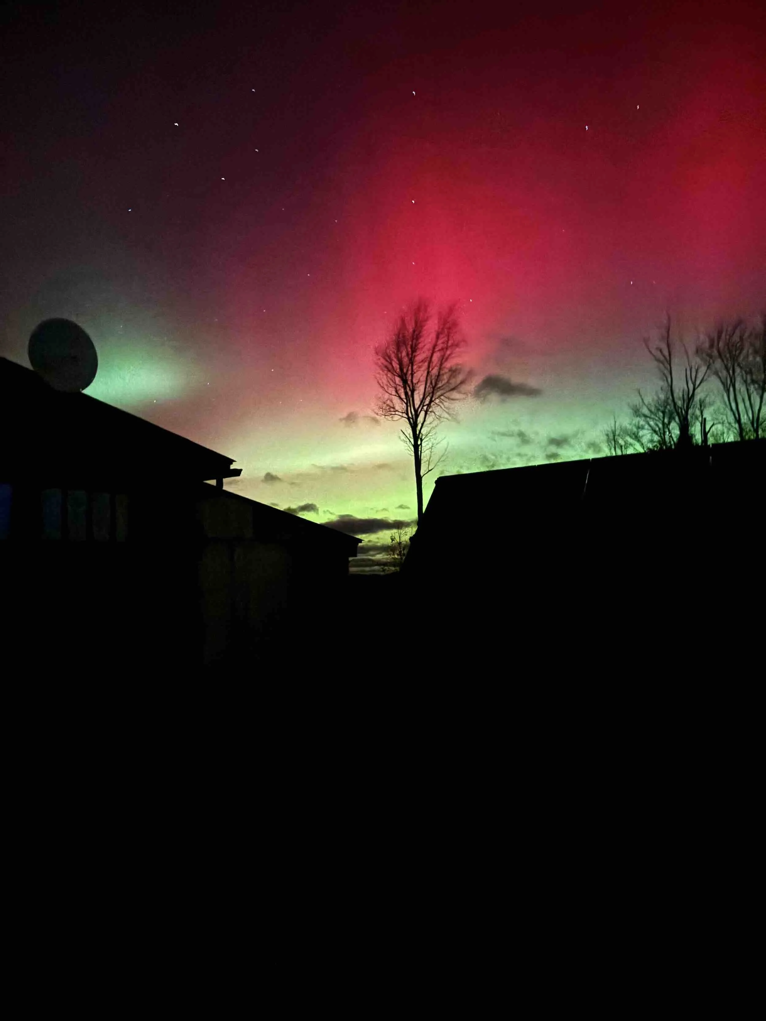 A winter night sky with aurora borealis in red and orange