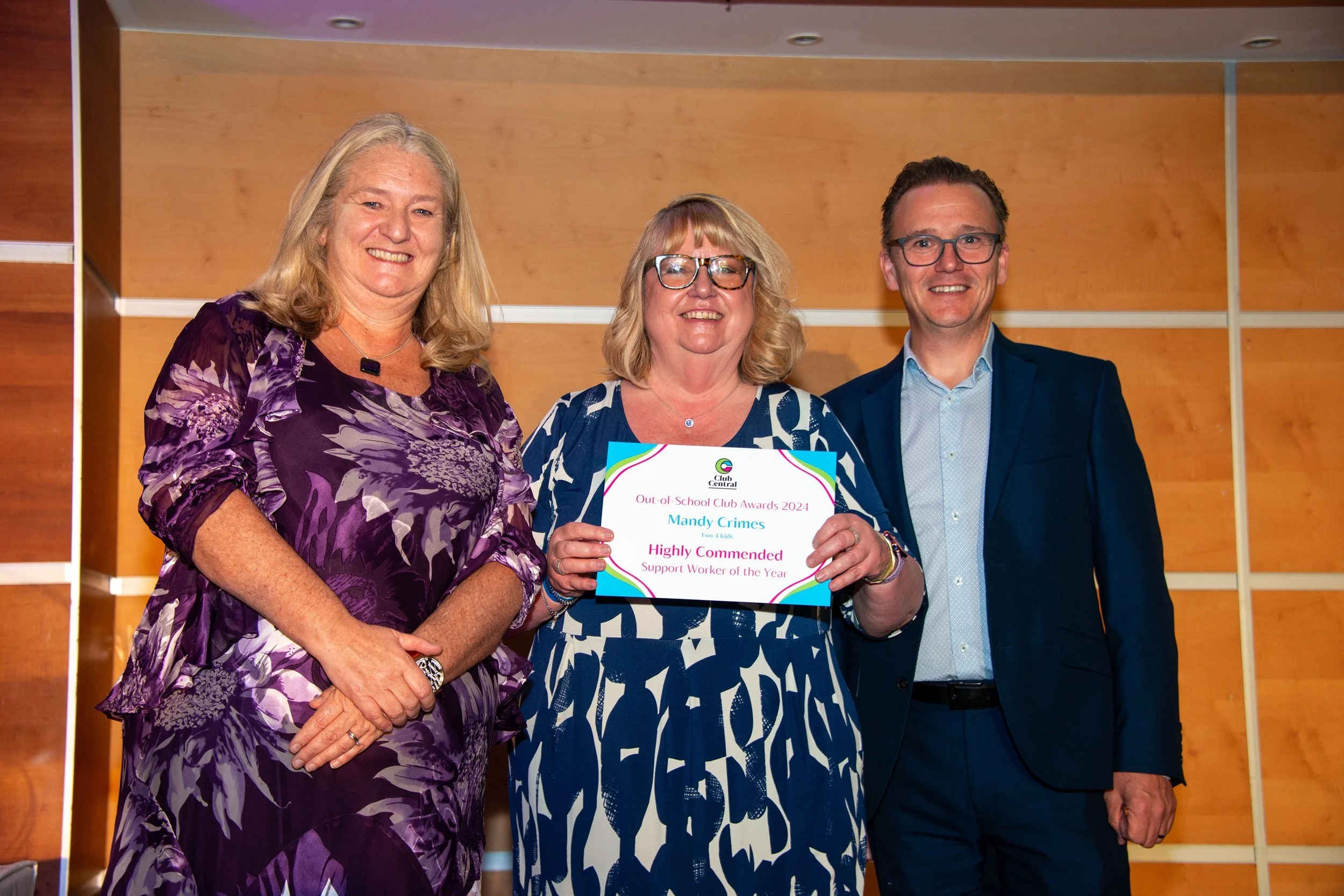 Two females and one male smiling at the camera