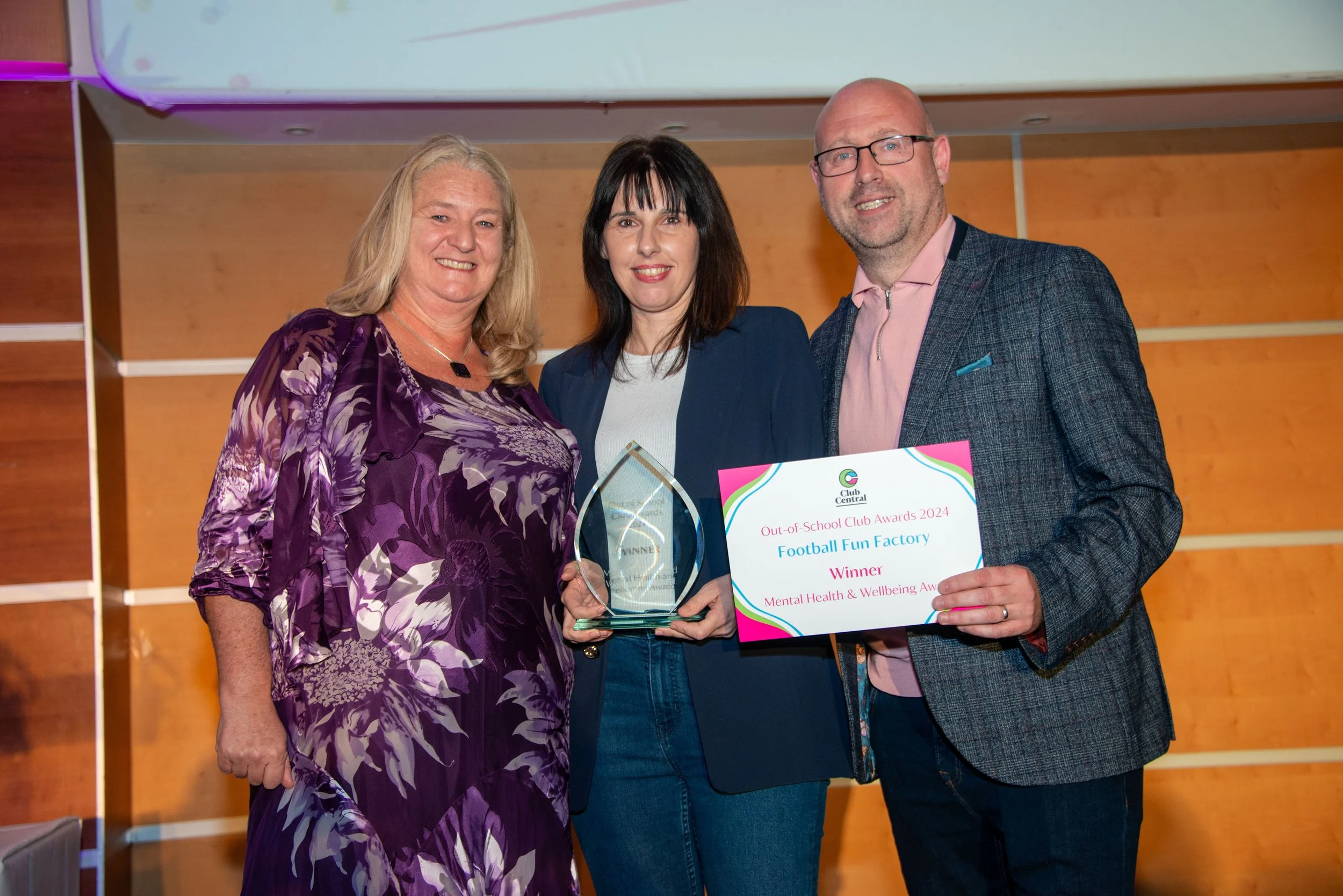 Two females and a male smiling at the camera