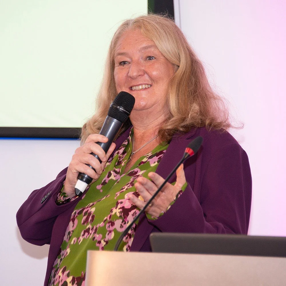 Tanya Petherick holding a microphone and speaking on stage