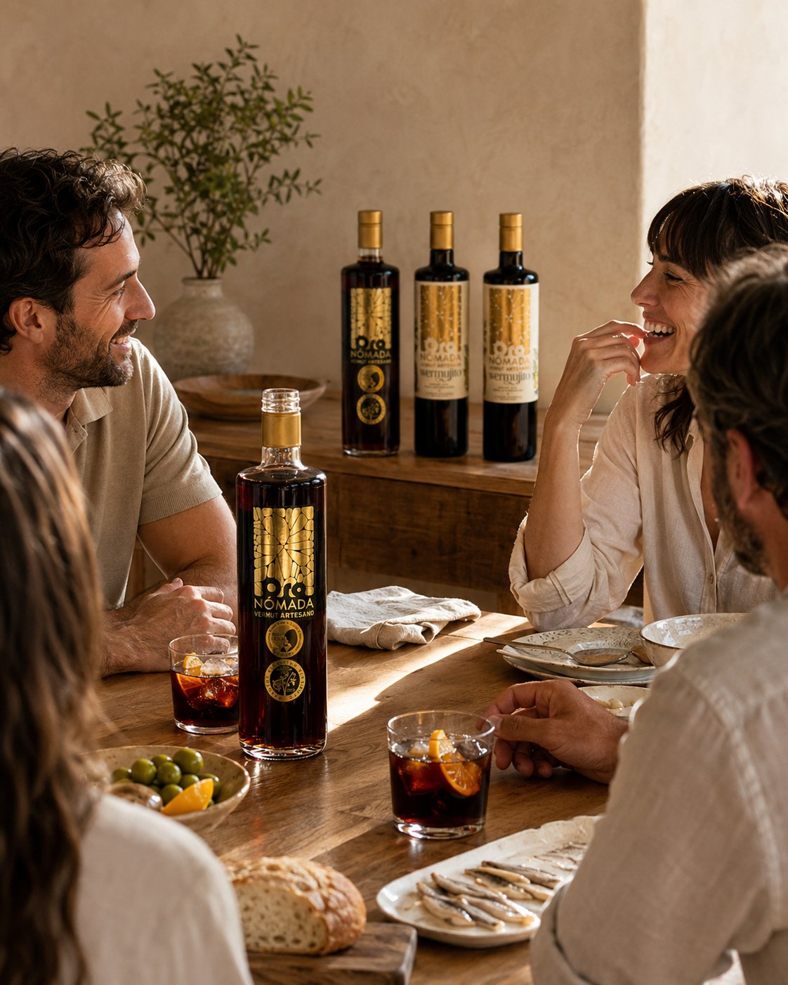 Sobremesa con Oro Nómada Original y tres botellas de La Colección al fondo