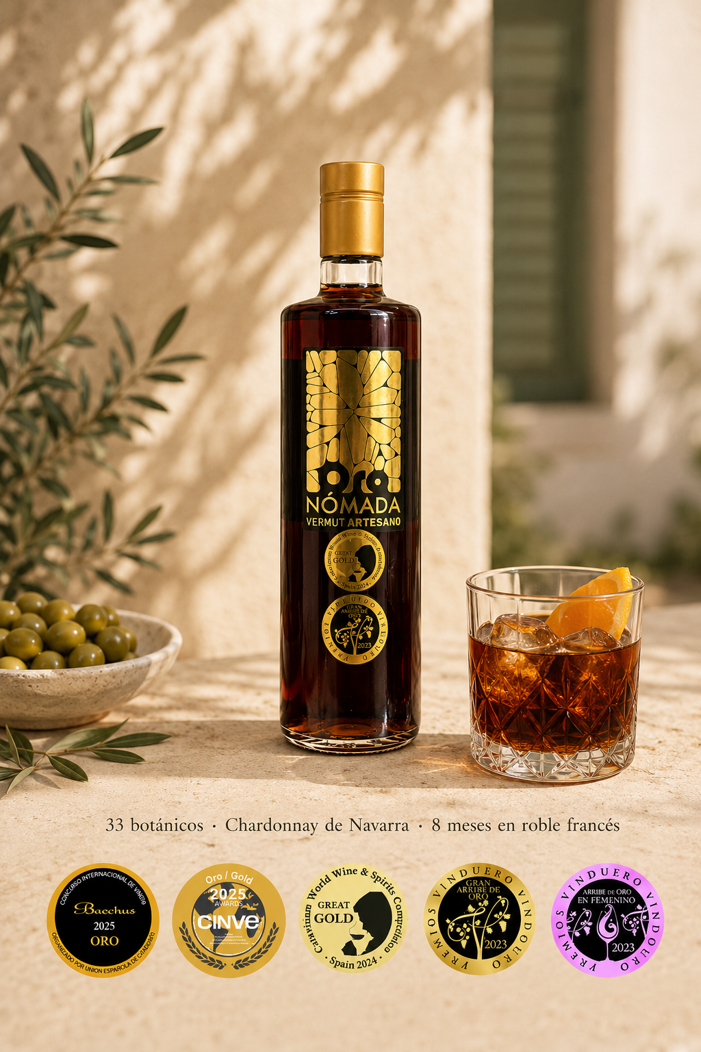 Botella de Oro Nómada Original con una copa de vermut con hielo y naranja, medallas y reconocimientos