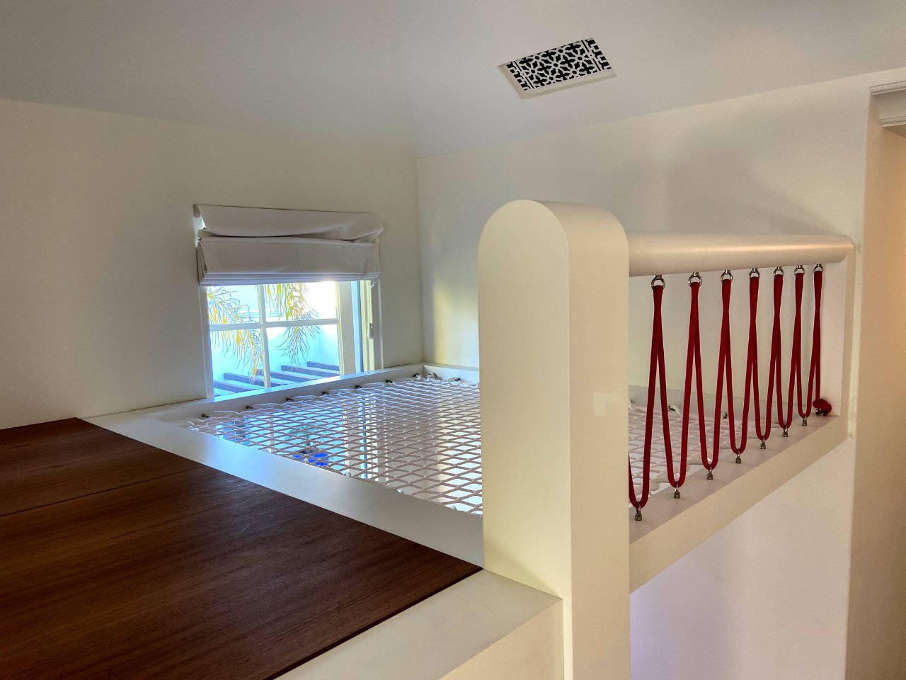 custom made Loft Bed featuring a hammock netting relaxation area, bordered by red rope railing.