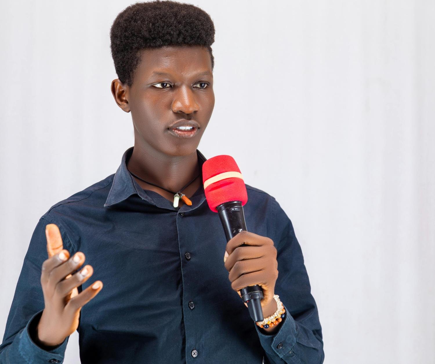 Young man speaking into a microphone while gesturing