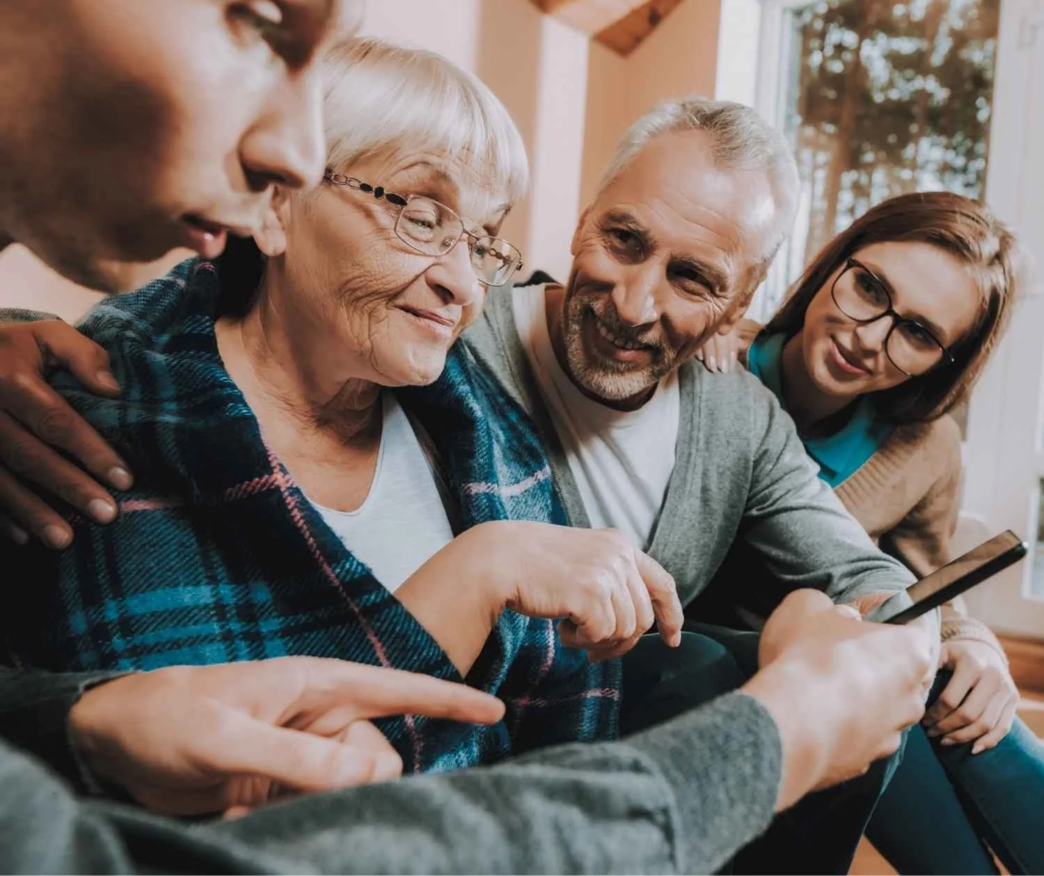 Older woman on speakerphone with family
