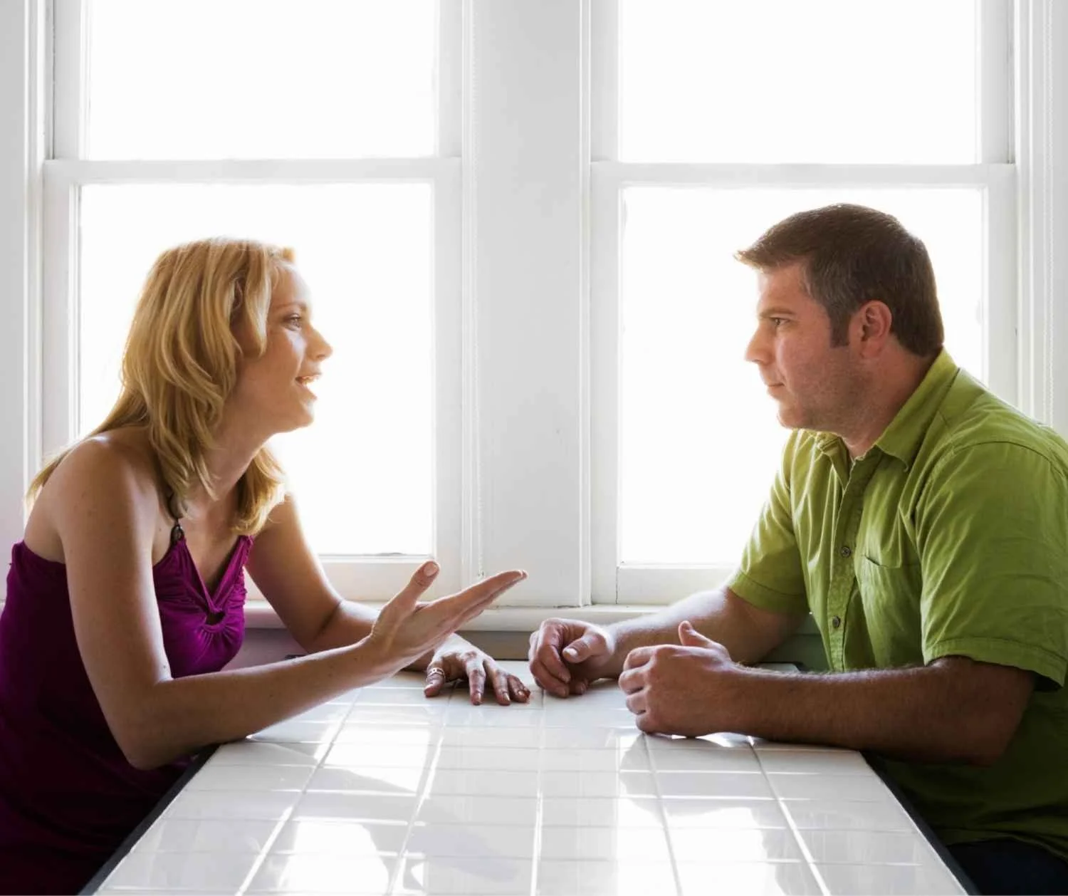 Couple talking at kitchen table, serious