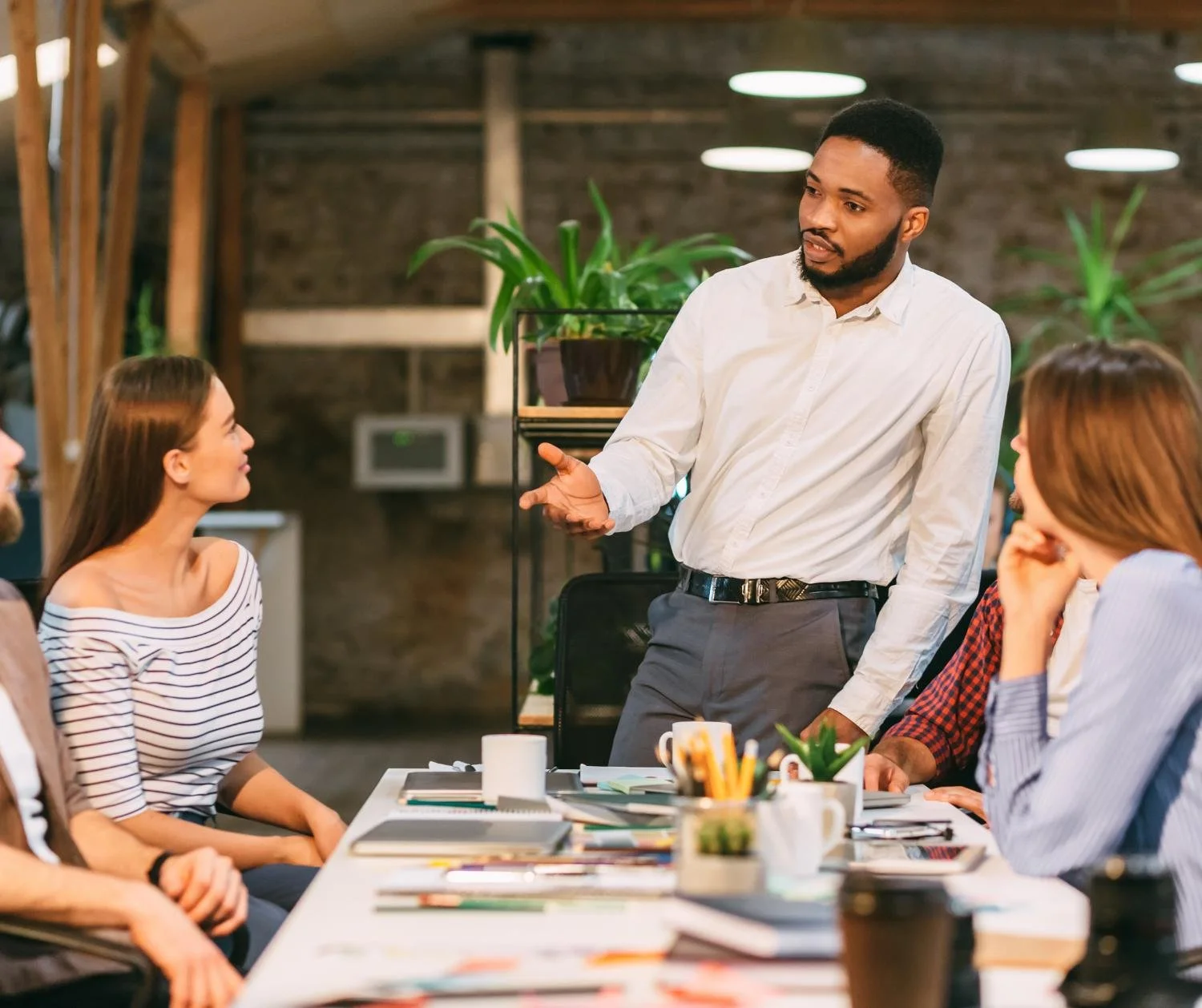 Man leading a workshop for a group around a table