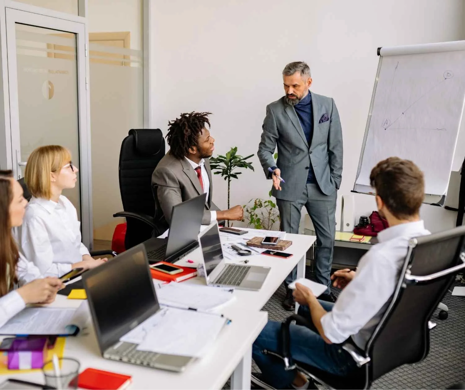 Man speaking to a small team in a meeting.