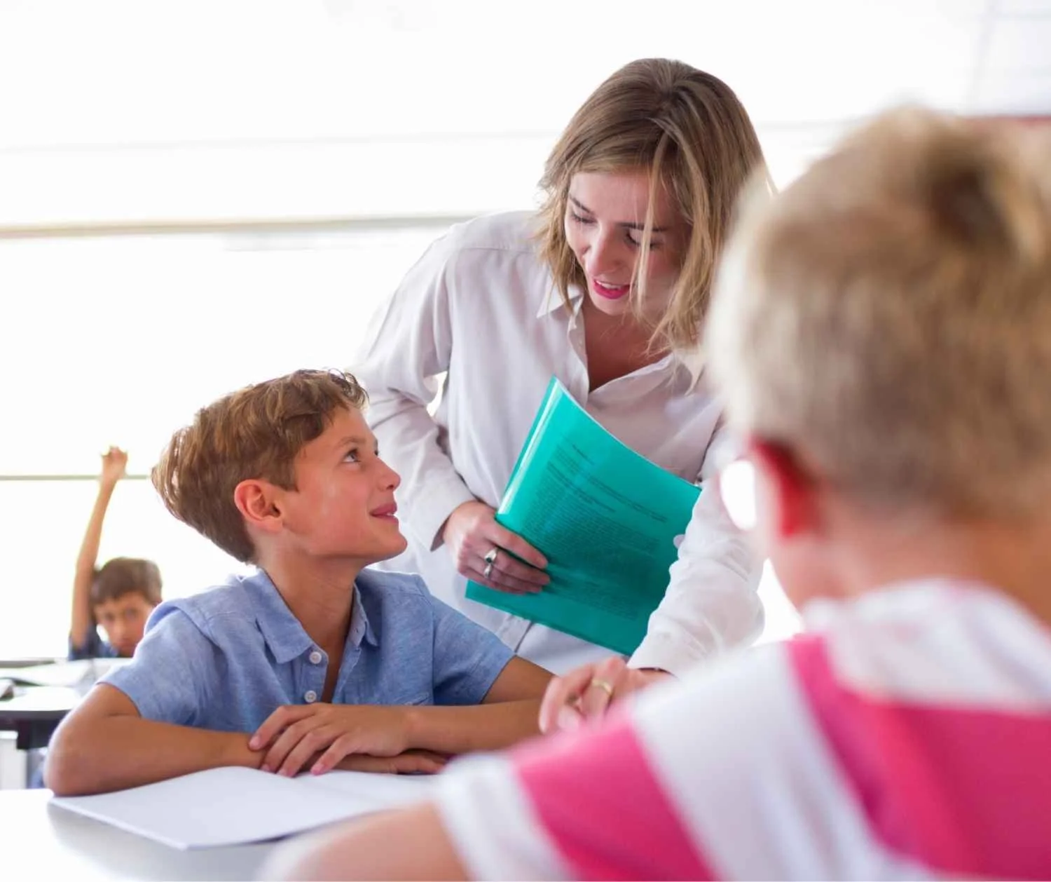 Boy speaking out in class while the teacher is mid-sentence