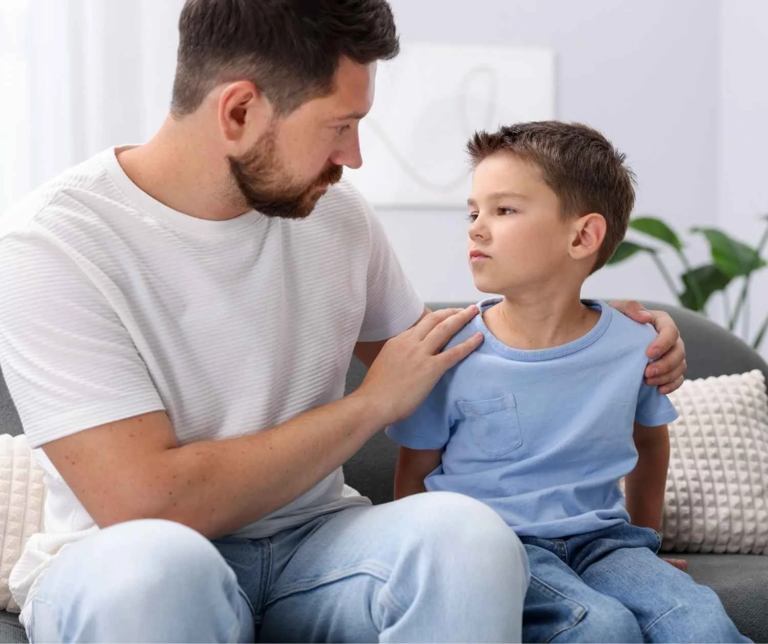 Father and son taking turns speaking on the sofa
