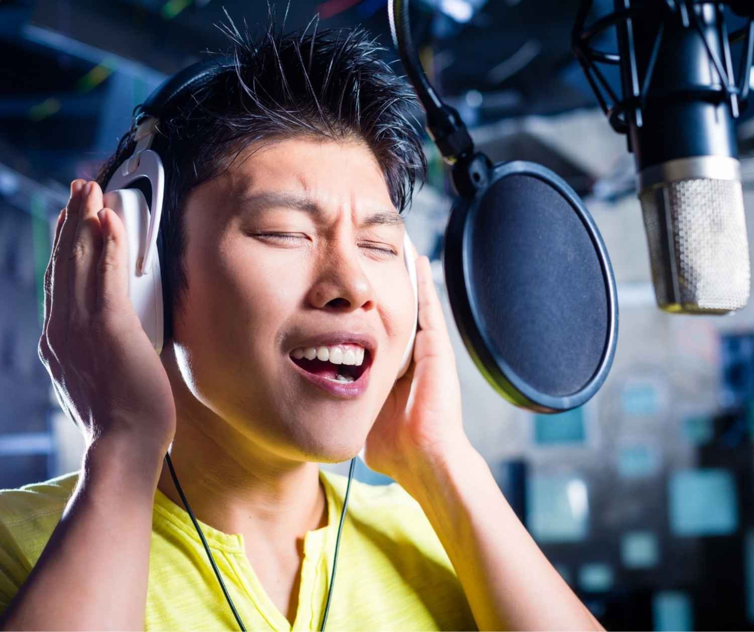 Man straining to sing high note, tense shoulders