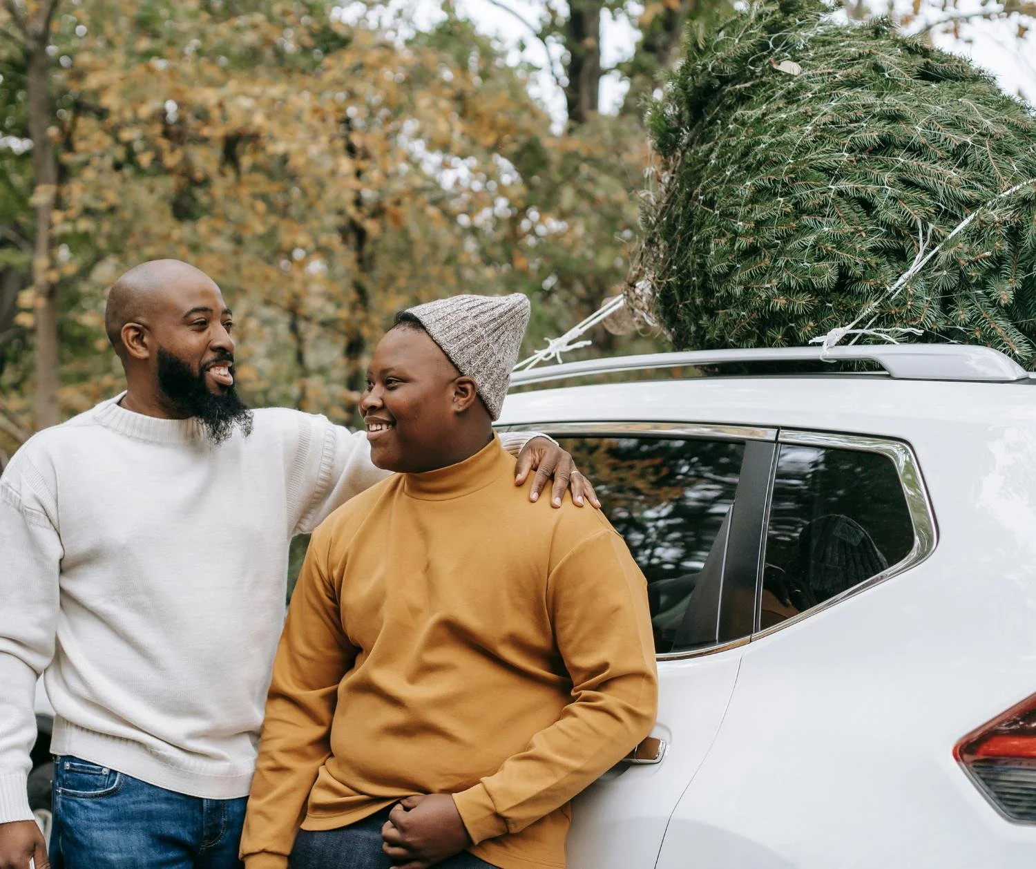 Father and teen son talking by a car