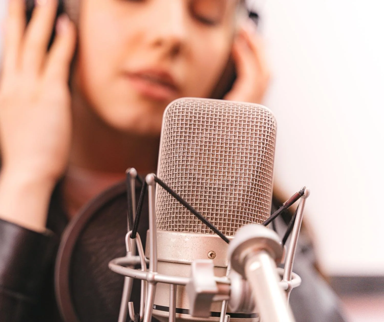 Woman in headphones at a studio mic