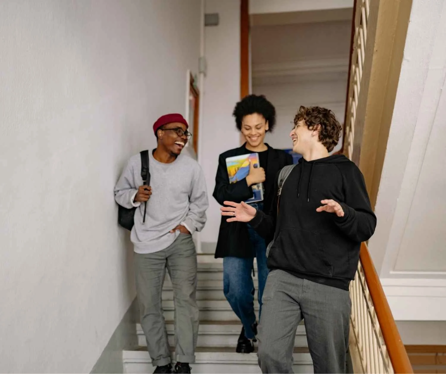 Three friends laughing on a staircase