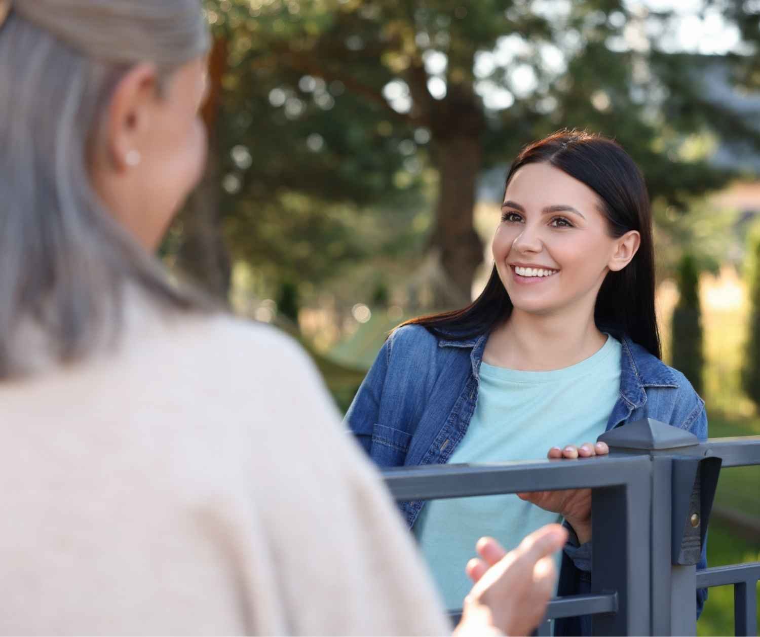 Woman chatting with a neighbor outside her home.