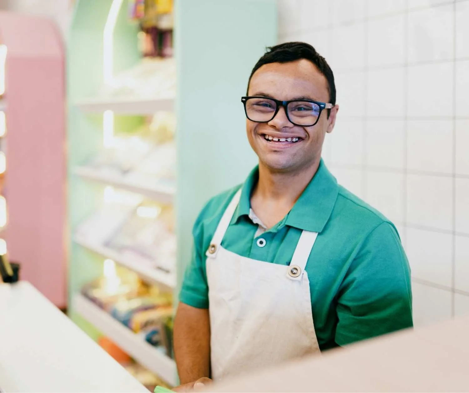 Young man with Down syndrome working behind a cafe counter.